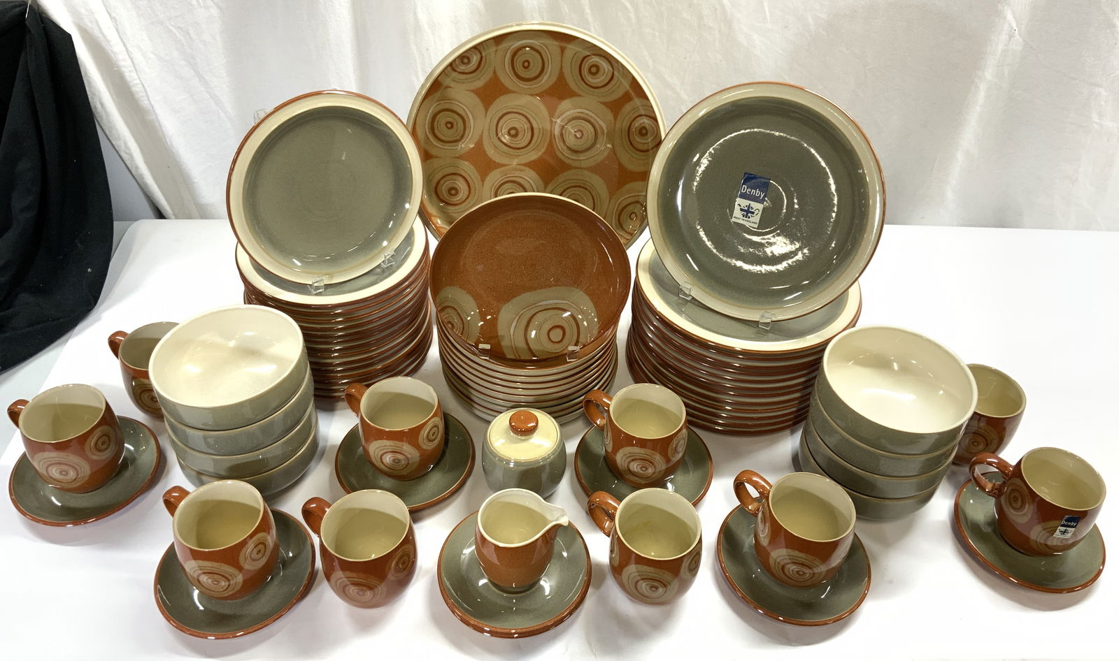 Set 67 DENBY Ceramic Serveware ENGLAND: Undersides marked DENBY MADE IN ENGLAND. Lot includes 15 salad plates, 13 dinner plates, 10 dinner bowls, 10 cups, 8 saucers, 8 soup bowls, 1 creamer dish, & 1 sugar dish, 1 serving dish. Serving Dish