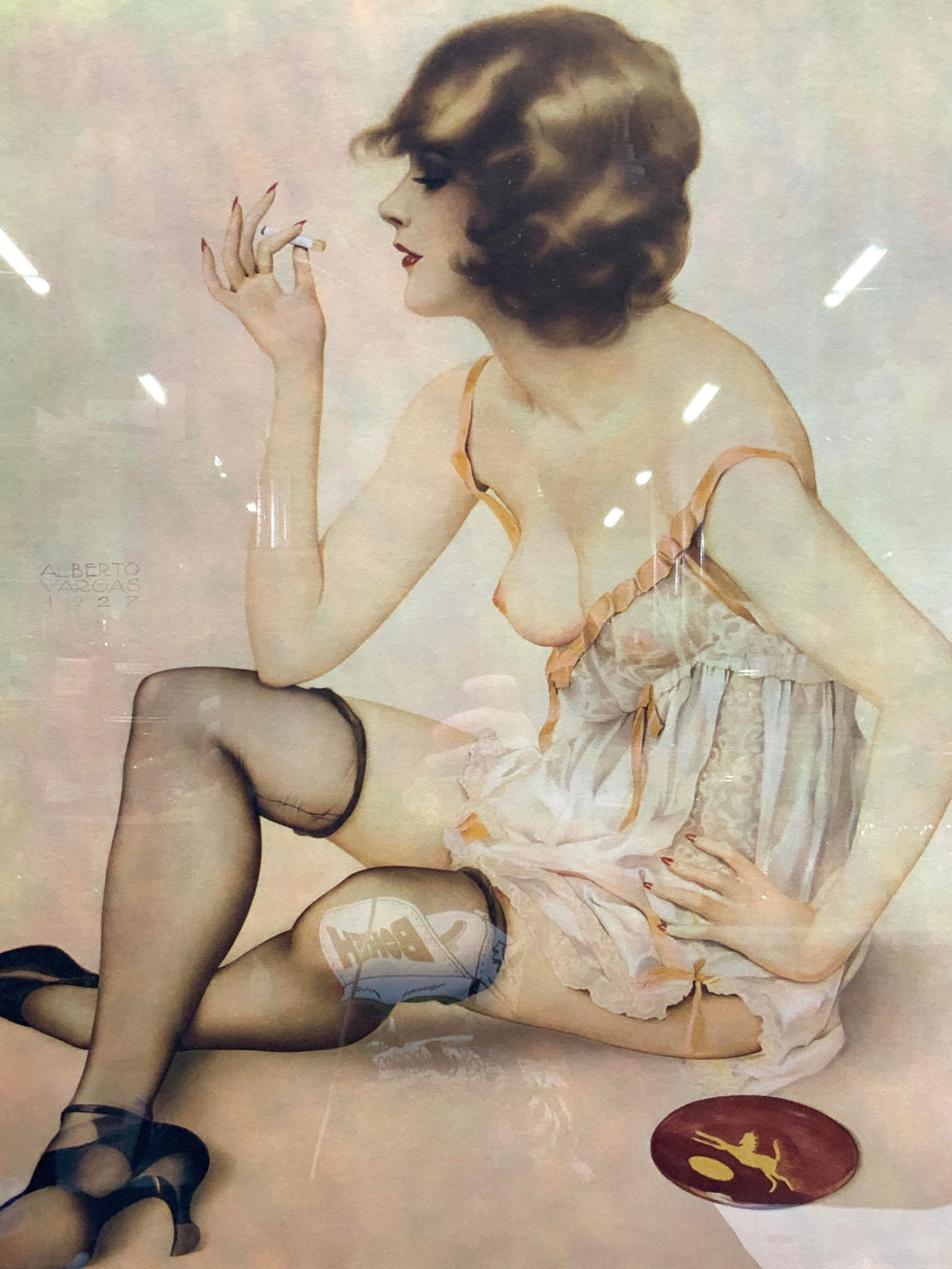 ATTR ALBERTO VARGAS Signed Female Figural Litho 31in: Signed on lower right corner in graphite, Vargas Depicts a woman seated in lingerie with stockings and high heels with a cigarette in her hand. Framed in a rose gold toned frame and tan toned mar boar