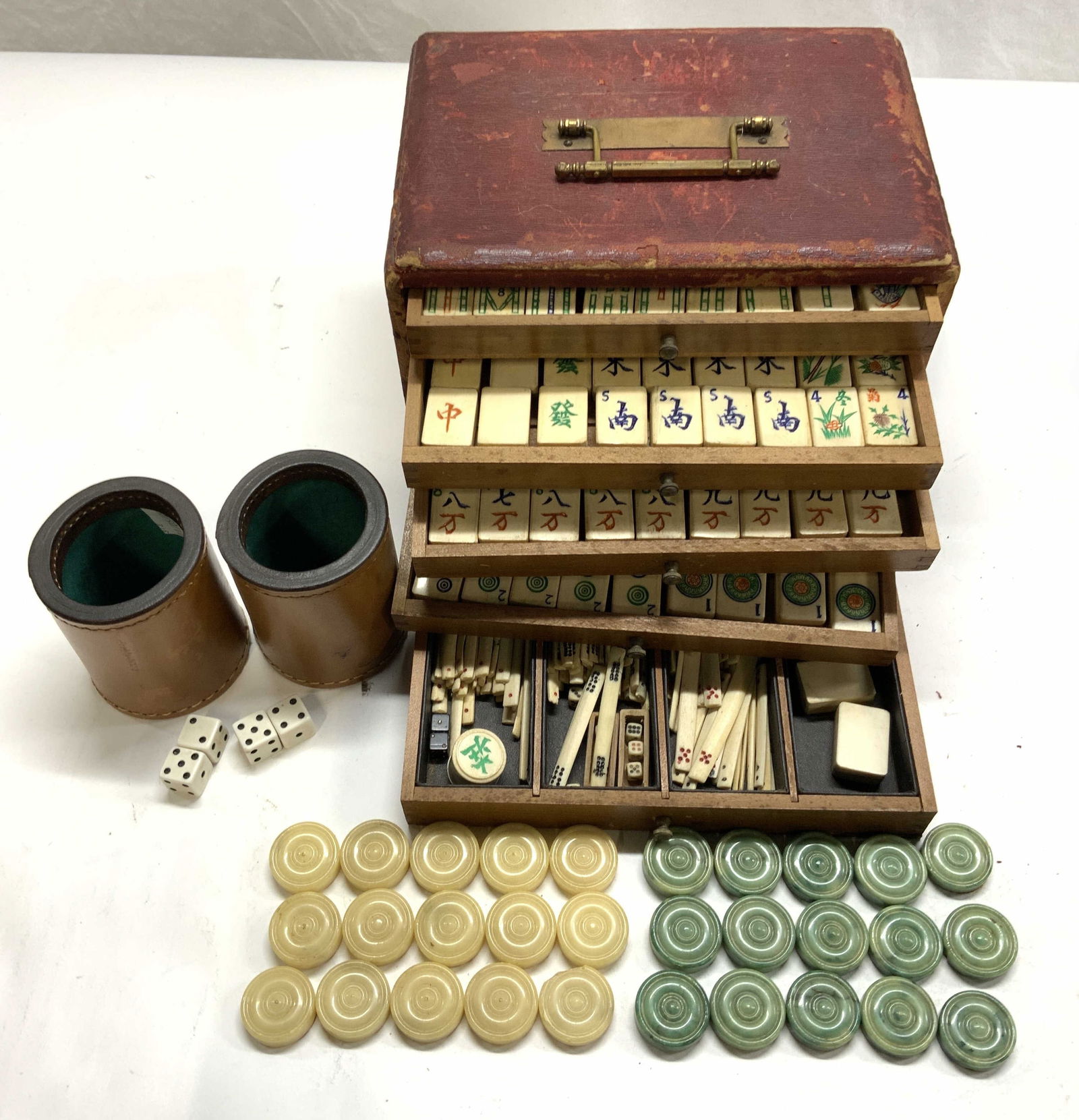 Antique Bone & Bamboo Mahjong Game Piece Set: Antique Mahjong Sets in carry case with brass handle. 5 drawer hand crafted wood case with wood drawers. Bone and bamboo handcrafted tiles. Miniature bone dice , carved bone pieces and painted. Box me