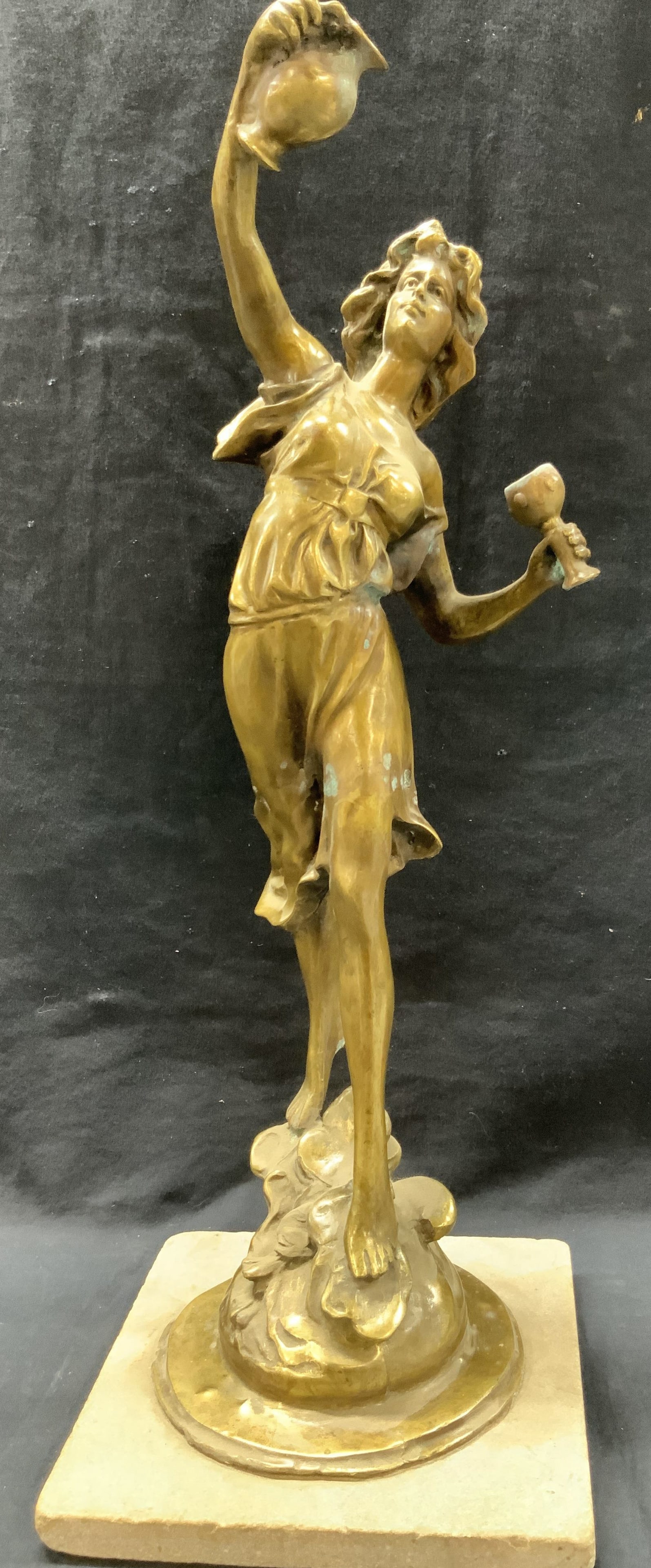 Vtg Moreau Style Bronze Wine Dancer Sculpture 2ft: Vintage figure of a woman holding a wine jug and a goblet in both hands standing on a mound. Figure is affixed to a stone base. Approx 24 inches tall and base being 9 x 9 inches. Possibly made of bron