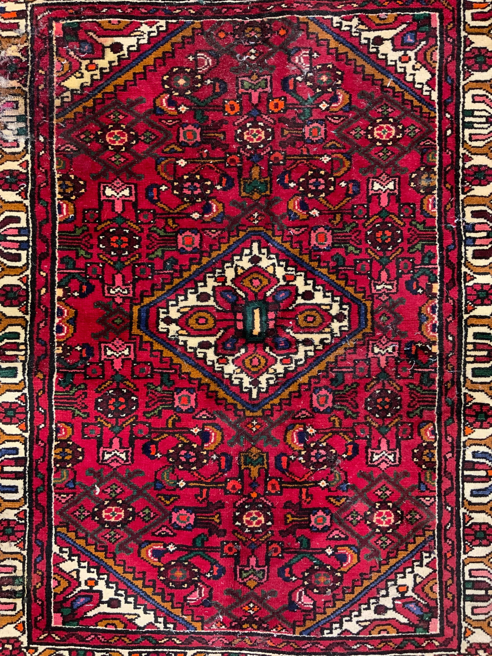 Vintage Handmade Persian Wool Area Rug: Rug is vintage. Piece is handmade and wool. Rug has intricate multi toned geometric detail. Rug has short cream toned fringes at edges. Piece measures approximately 58 inches long 43 inches wide. Rug,