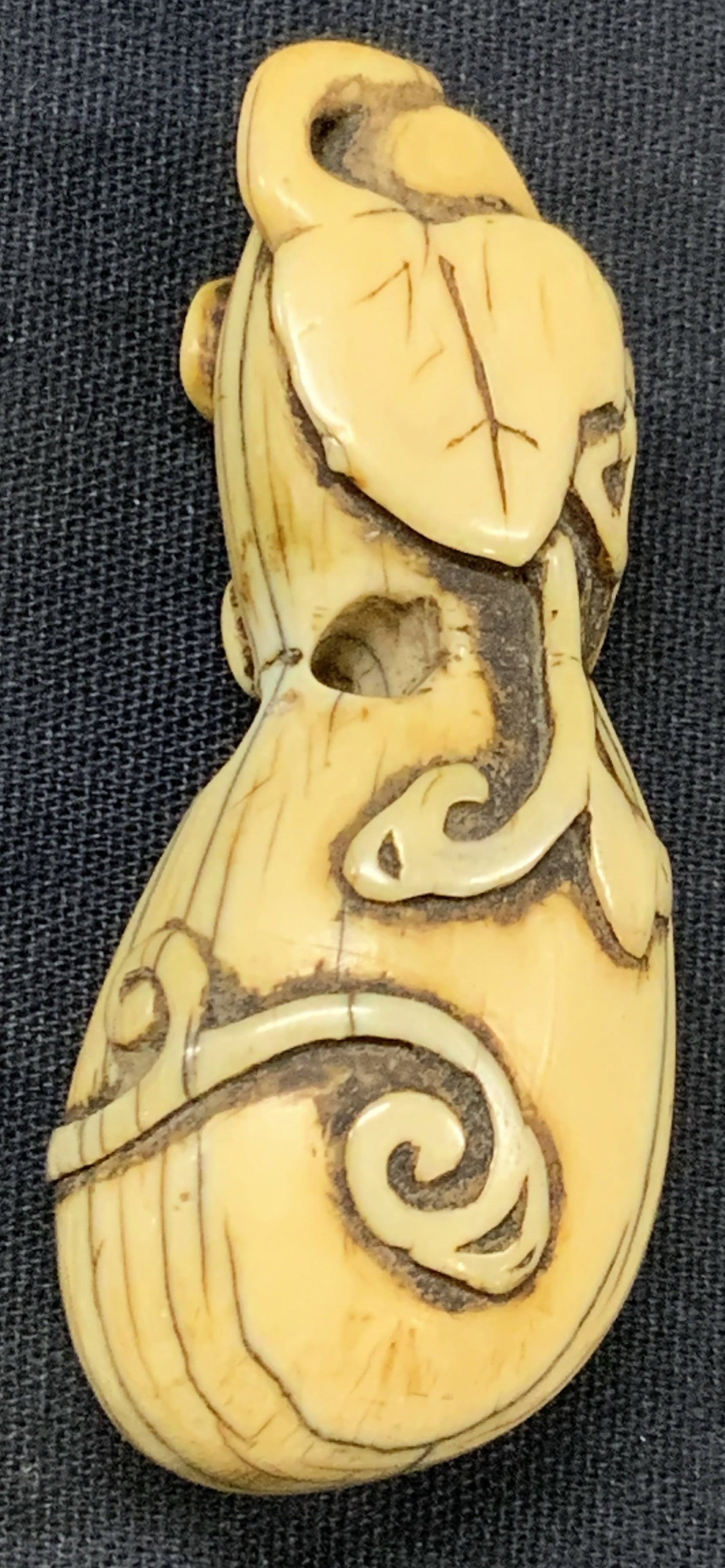 Carved Bone Japanese Netsuke Gourd: Japanese Netsuke made of carved bone, made to resemble a gourd with raised textured steams and leaves. Approx 2.5 inches long. Moderate wearing to bone and minor loss to top of gourd, Vintage Japanese
