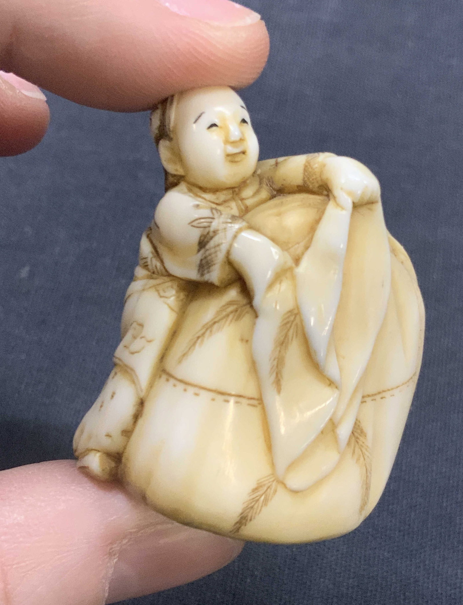 Vintage Carved Bone Netsuke Child W Bag: Vintage, possibly antique bone Netsuke depicting a child next to a bag almost the height of the child. High detailing in the childs clothing and face. Approx 1.5 inches tall and 1 inch wide. Moderate 
