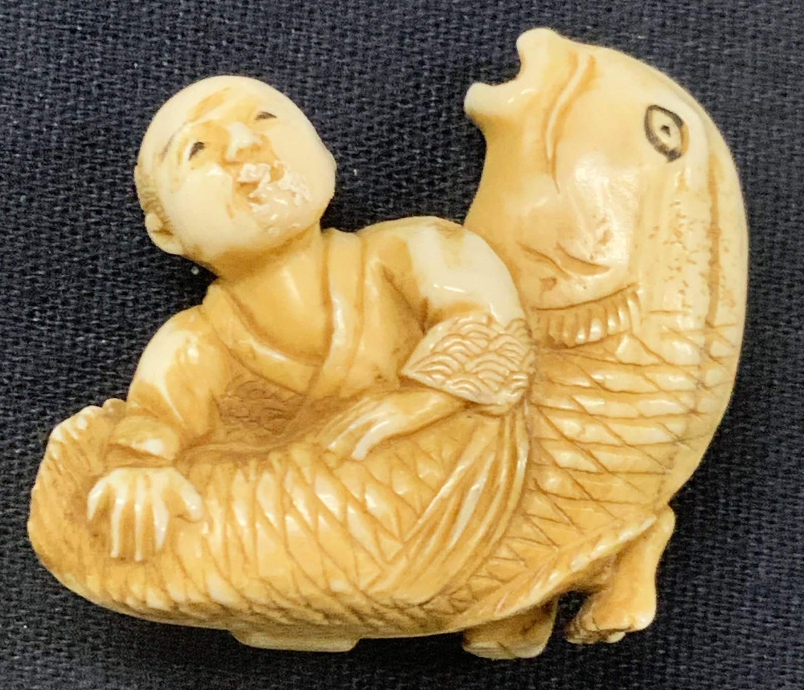 Vintage Carved Bone Netsuke Man W Fish: A vintage, possibly antique carved bone netsuke depicting a man wrestling a large fish bigger than the man. High detailing in the fishes scales, and teeth and the mans clothing. Approx 1.25 inches tal