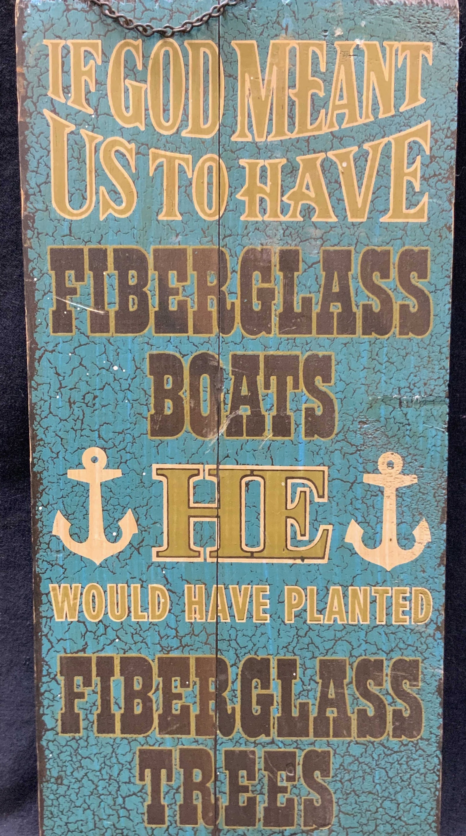 Fiberglass Boats Wooden Art Panel: A wooden panel with a hanging chain that reads If God meant us to have fiberglass boats He would have planted fiberglass trees. These worlds over a dark teal tone. Approximately 15 x 7.25 inches. No f