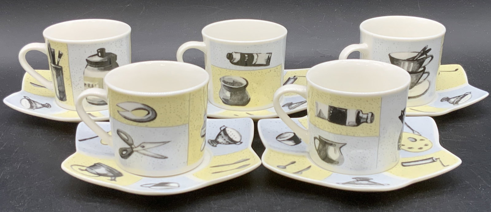 10 ALTENKIRCHEN Demitasse Porcelain Cups & Saucers: A set of ten porcelain cups and saucers. Saucers are Star style forms, cups & saucers feature home decor inspired motifs. Imagery includes books, kettles lamps, phones, and more. Undersides signed KON