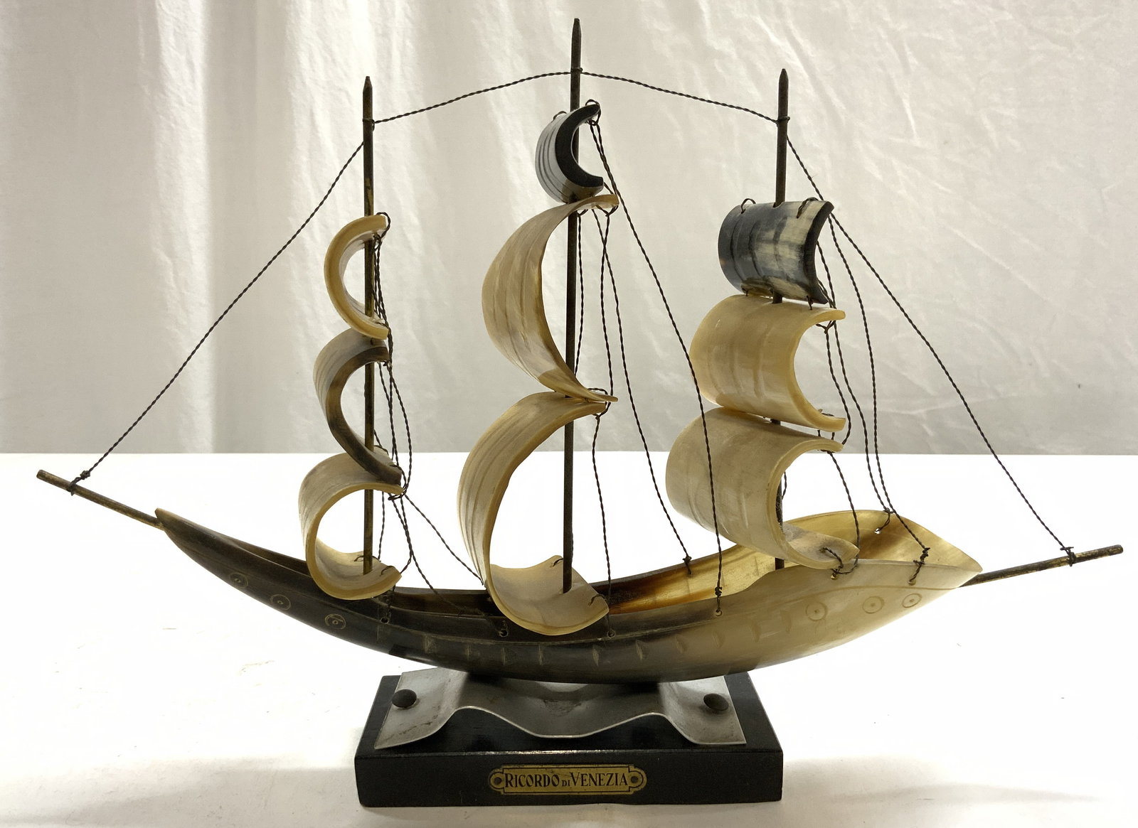 RICARDO DI VENEZIA Vintage Carved Bone Ship Model: Plaque on base reads RICARDO DI VENEZIA. Piece appears to be vintage. Ship model is crafted from carved bone. Piece has black toned wooden base. Some areas of bone have geometric relief detail. Measur