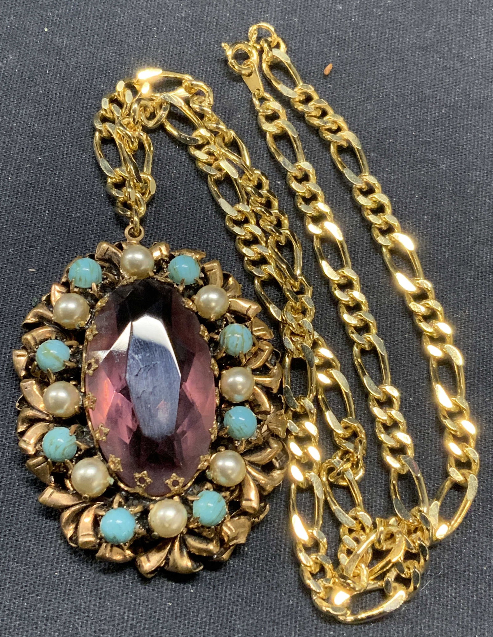 Gold Tone Crystal Pendant Necklace: Gold tone necklace with purple crystal, faux pearl, and turquoise Cabochon pendant. Drop length approx 9 inches. Pendant approx. 2 x 1.5 inches. Some surface wear including scratching observed. Estate