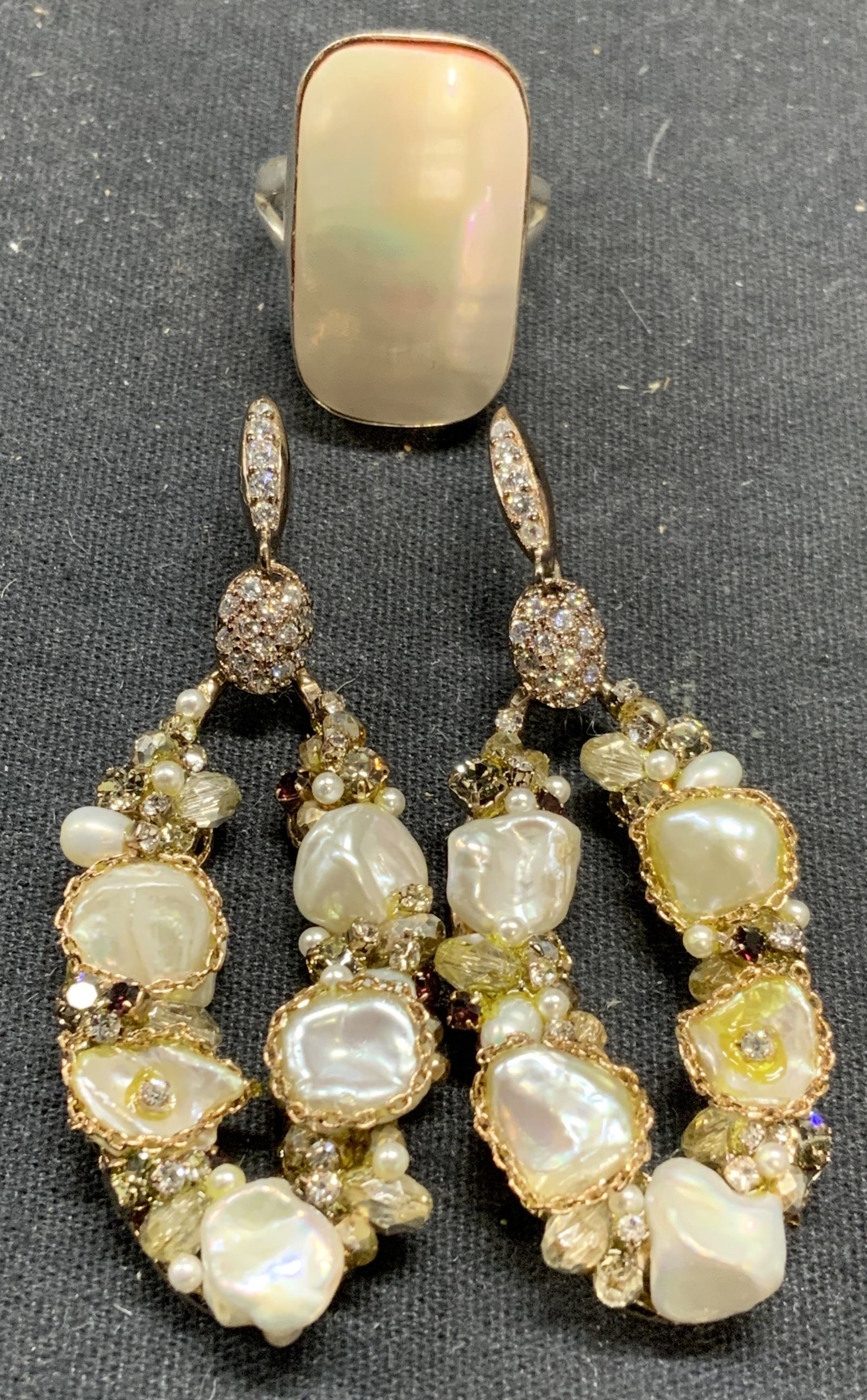 2 Faux Pearl Earrings, Sterling Silver MOP Ring: Lot of 2 jewelry pieces. Vintage sterling silver and mother of pearl ring. Marked 925 to interior band. Ring size 7.5. Ring needs to adjustment to setting. Setting measures approx. 1 x 5/8 inches. Tot