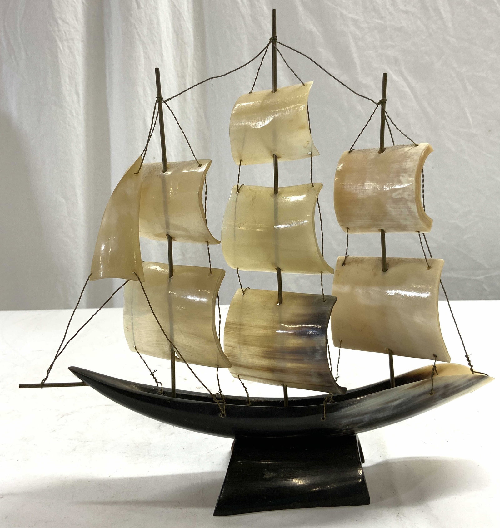 Vintage Carved Bone Ship Model: Piece appears to be vintage. Ship model is crafted from carved bone. Piece has black toned bone base. Bone has black, brown & cream tones. Measures approximately 11.25 inches tall & deep 2.75 inches w