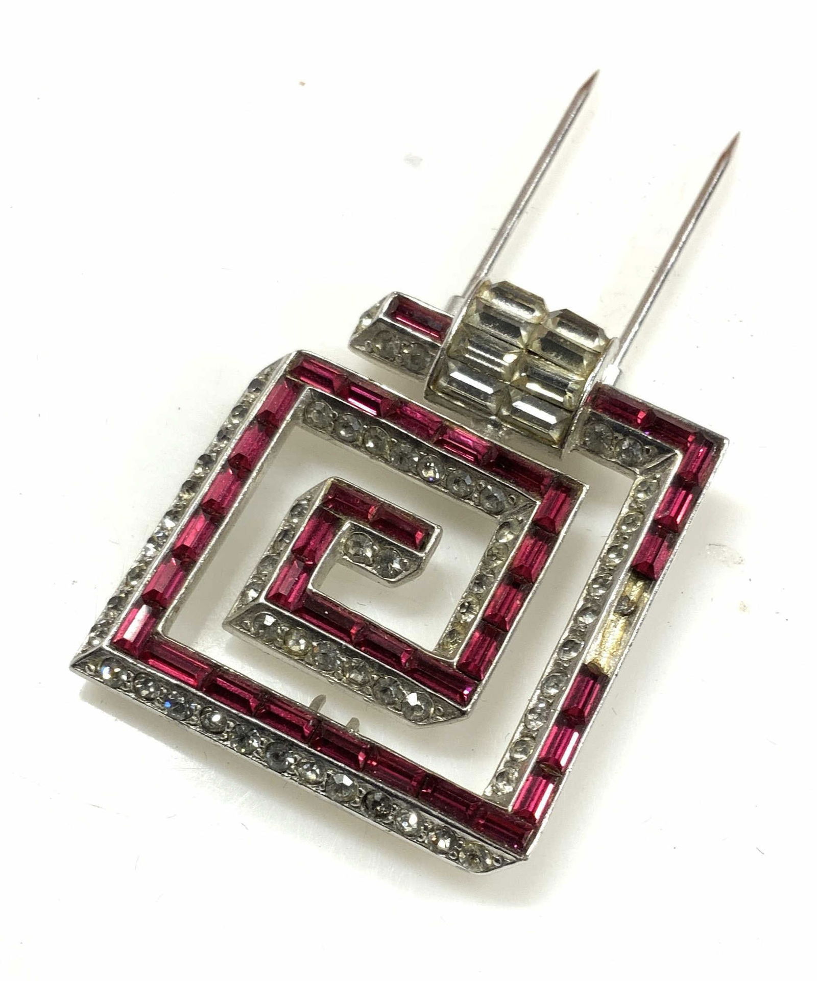 Crystal Greek Key Fur Clip: Crystal fur clip in Greek Key shape with baguette and round red and clear crystals. A couple baguettes need replacement. Up cycle as a hair clip. Set in silver tone metal, 1.5 x 1.25 in. Art Deco crys