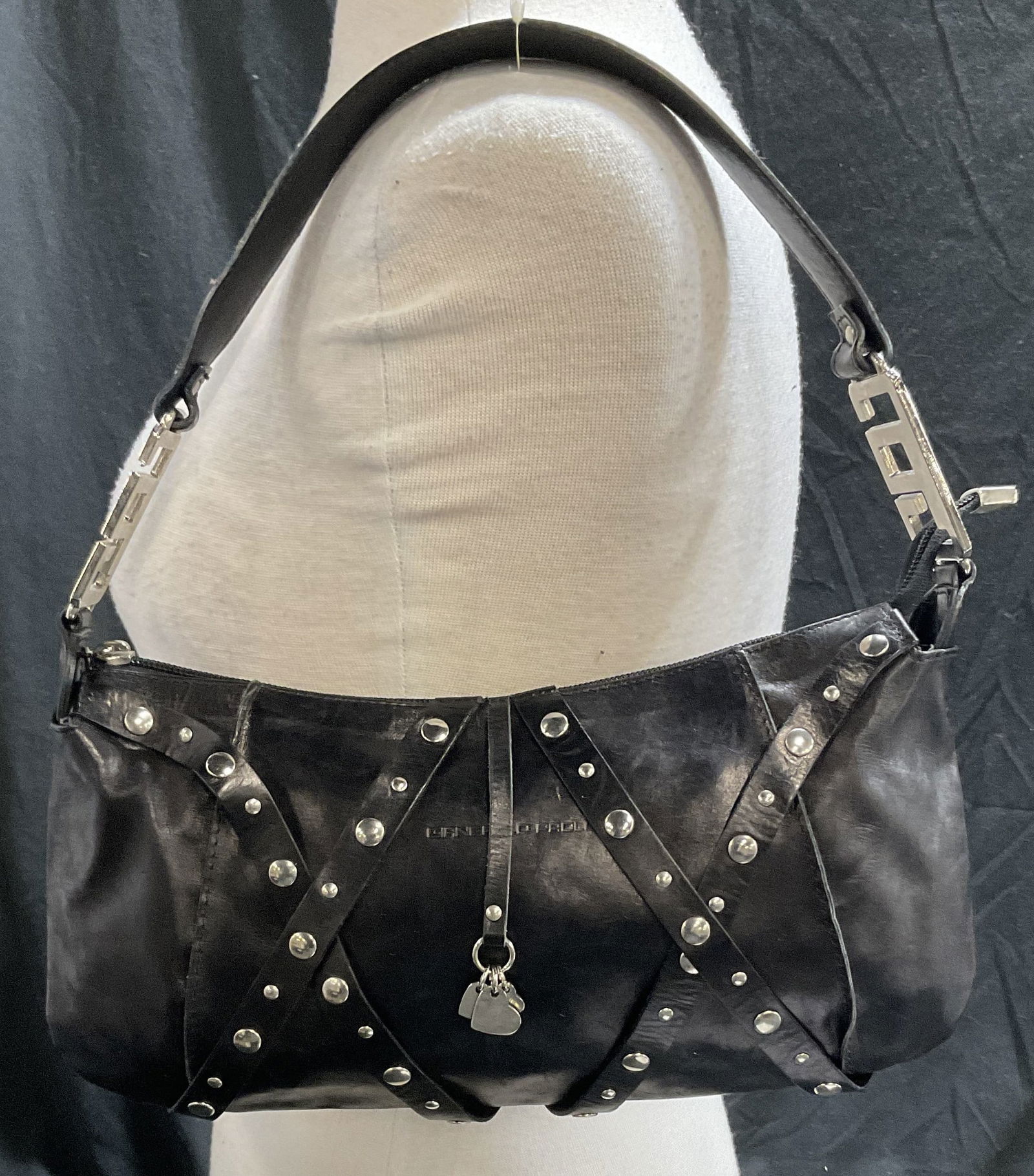 GIANCARLO PAOLI Black Leather Shoulder Bag: GIANCARLO PAOLI Black Leather one strap Shoulder Bag with zipper closure and silver toned studs on exterior. Wine colored lining. One interior zippered pocket. Measures approx. 13W x 14H in. Some surf