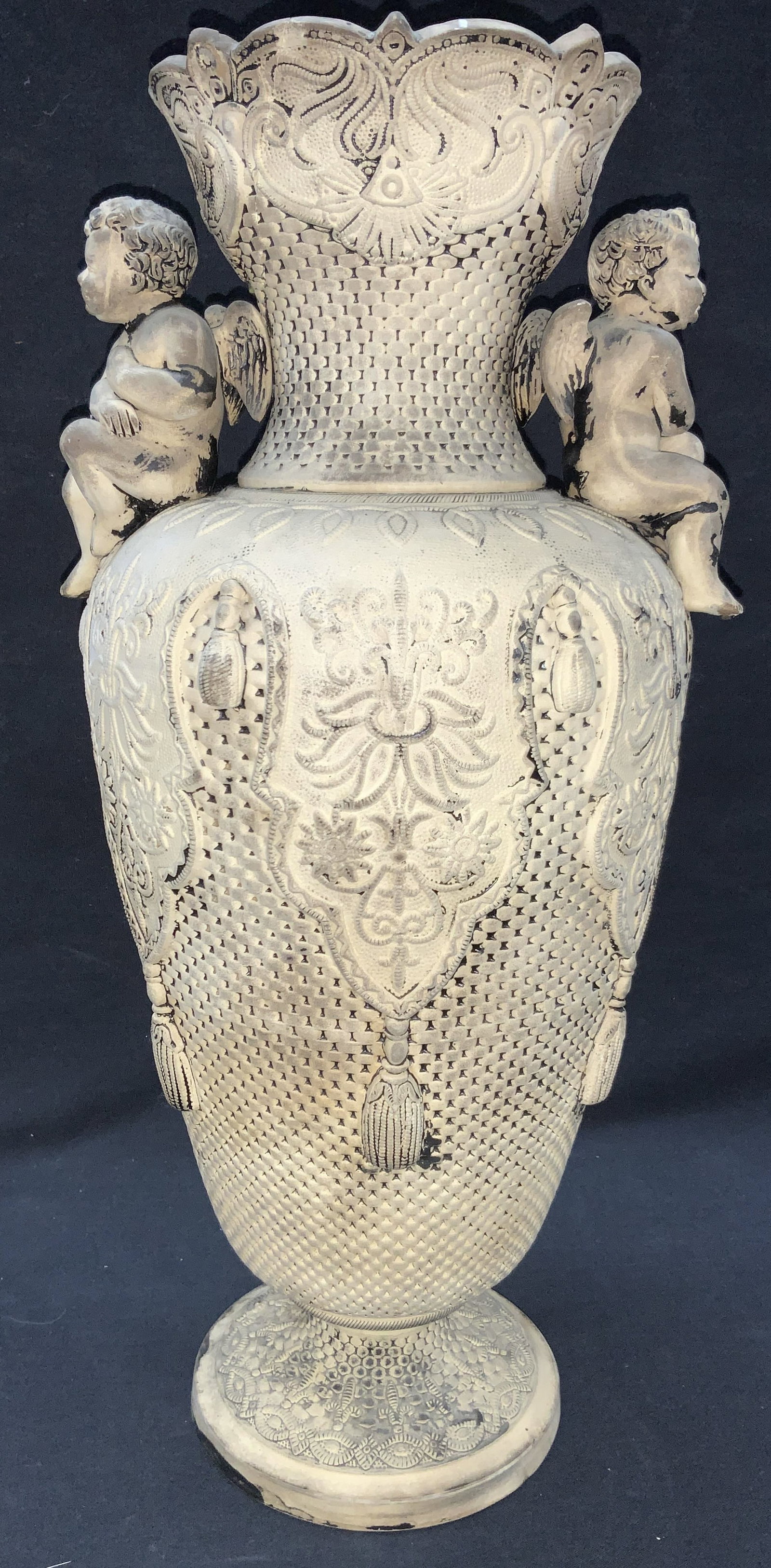 Vintage Stamped Cherub Clay Vessel 1ft5inH: Stamped on underside, possibly reads Glisal, 1702 with an X marked. Vintage possibly antique. Exterior is adorn with texture that resembles weaving with tassels and embroidery style designs on tops wi