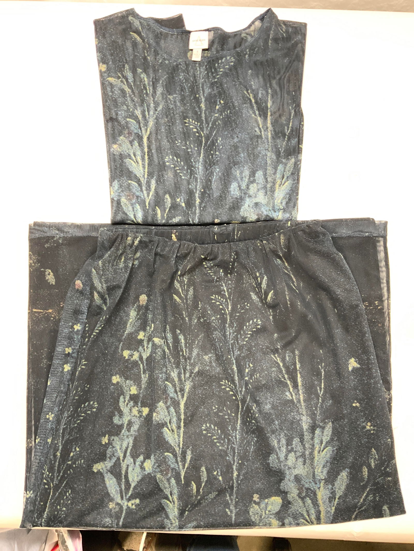 Anne Klein Matching Skirt & Blouse Set: Anne Klein petites. Navy floral mesh skirt and blouse. Skirt is a size 2 with stretch band waist. Blouse is size 6 and has transparent sleeves. Both garments lined. Mesh polyester and spandex. Anne Kl