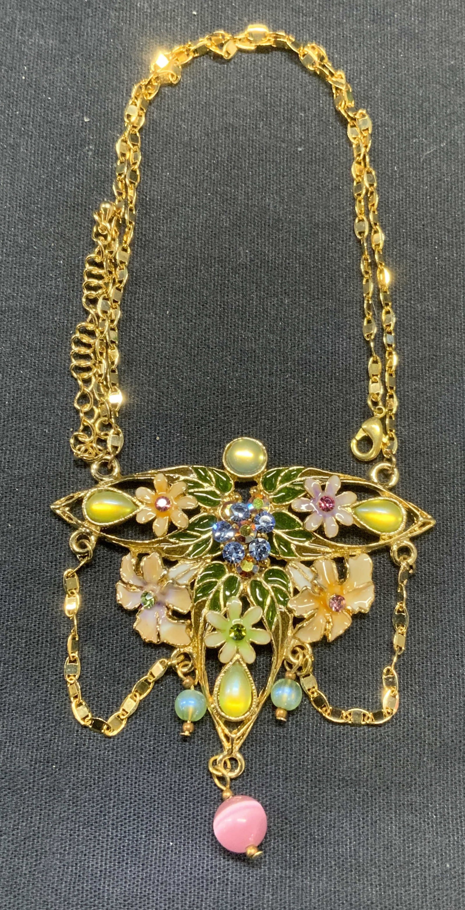 Gold Tone Crystal Flower Pendant Necklace: Gold tone pendant necklace with enamel and crystal decoration. Drop length approx. 9 inches. Pendant measures approx. 2.5 x 2.5 inches. Some surface wear including scratching observed. Estate jewelry,