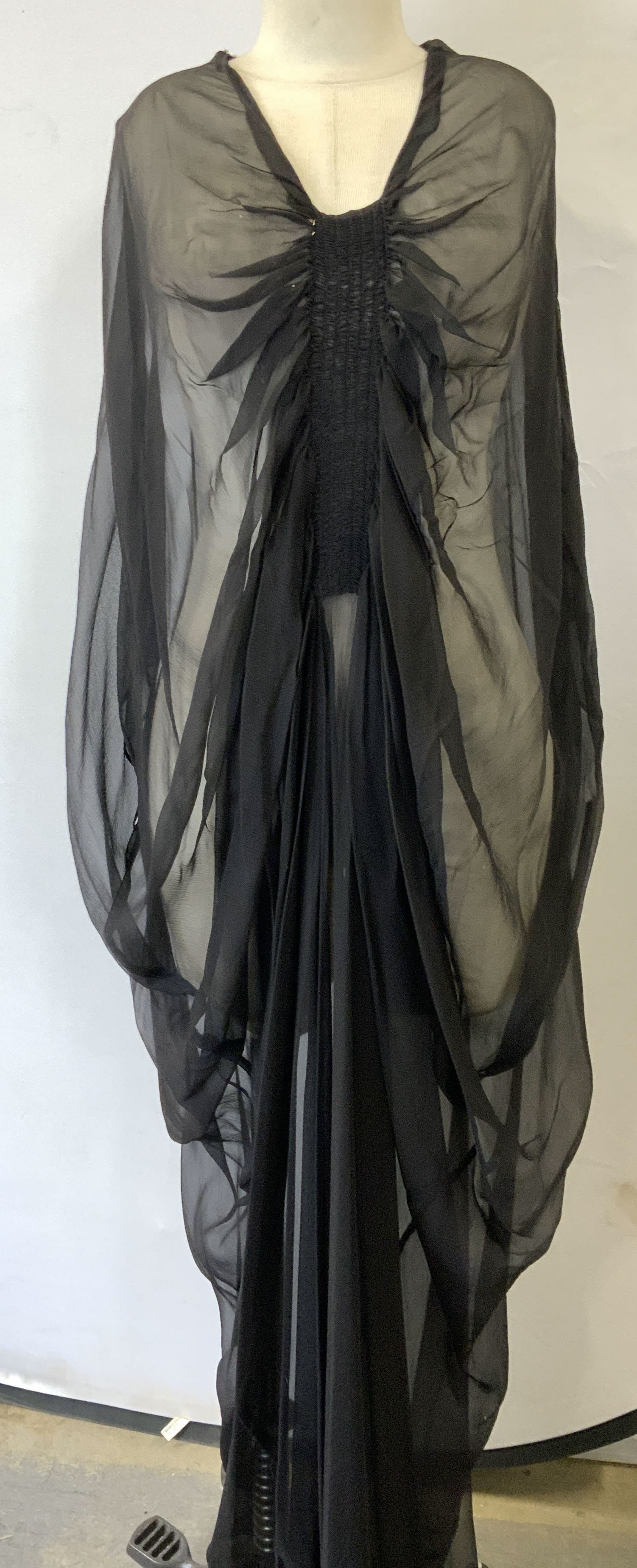 Sheer Black Silk Muumuu Evening Wear: Sleek sheer muumuu with a rouched center and Art Deco style. Very low drop sleeve in which wrist of lower arm shows through. Narrower lower body. Bottom hem will need to be mended as hem is fraying. 5