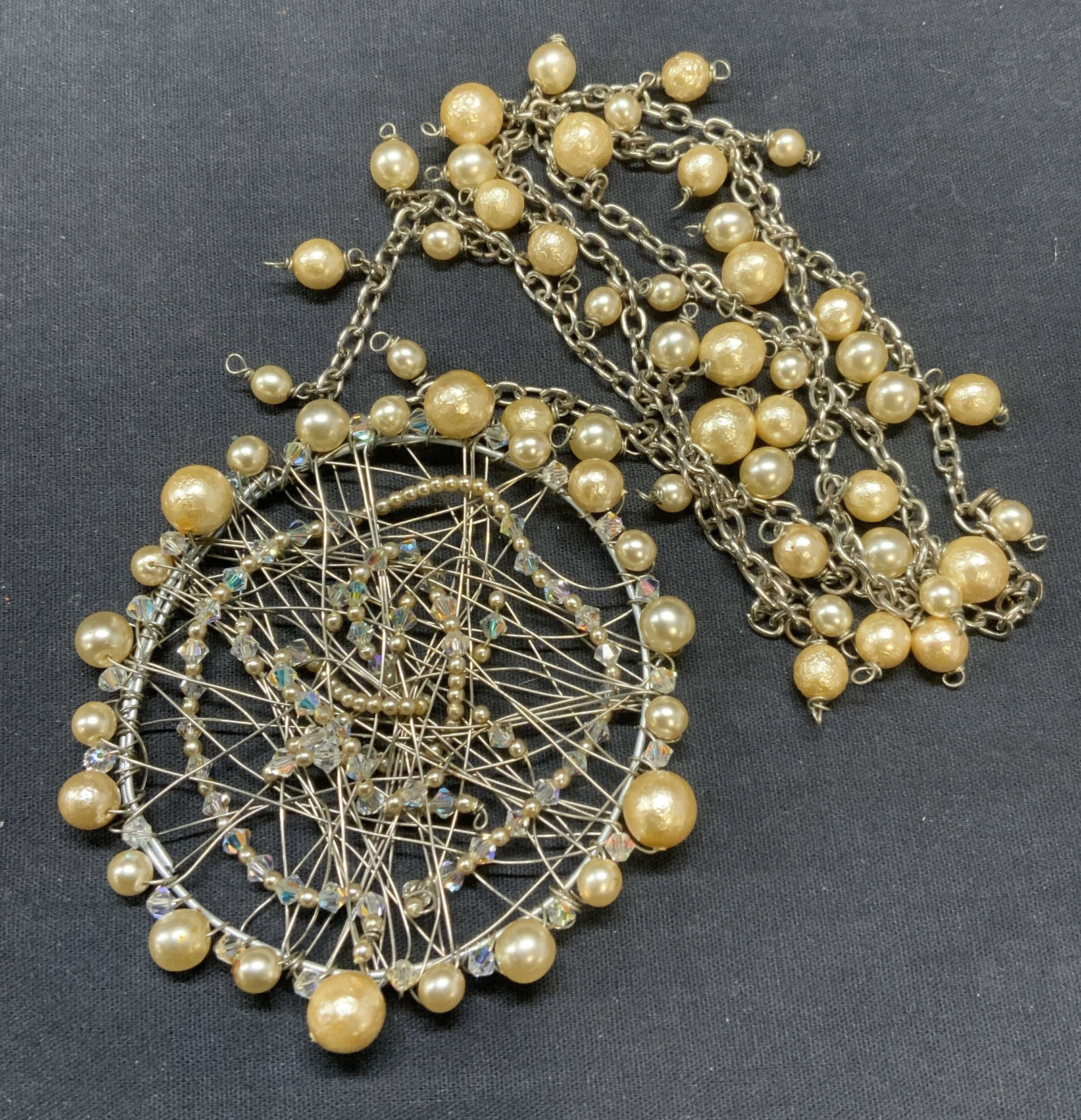Silver Tn Faux Pearl Beaded XL Pendant Necklace: Silver Tone faux pearl beaded pendant necklace. Champagne toned faux pearl beads. Drop length approx. 15 inches. Pendant measures approx. 3.25 inches diameter. Includes jewelry box. Some scratching ob
