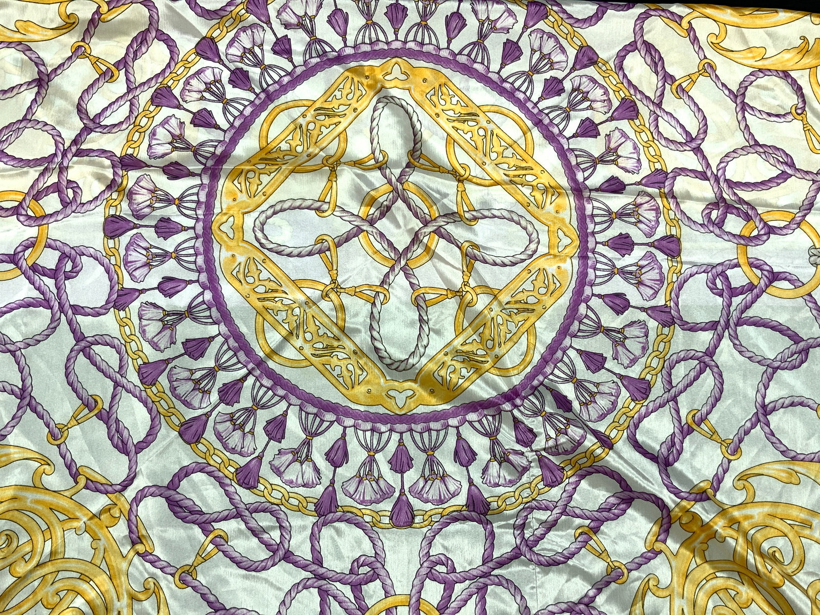 Joolay Lavender & Gold Tn Scarf, Italy: Marked on tag Joolay 100% Polyester, adorned in lavender and gold toned ropes interlocked in swirl patterns. Approx 35 x 35 inches Minor wearing to edges of scarf. Joolay scarf, scarf, ladies fashion,