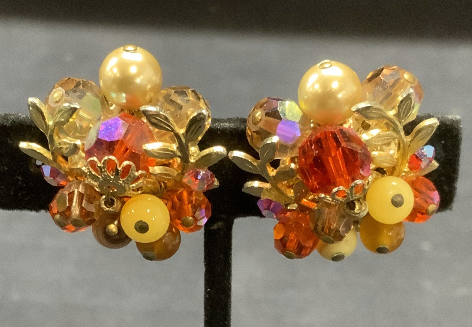 Vintage Vendome Gold Tone Crystal Earrings: Vintage Vendome god tone crystal cluster earrings. Red crystal and of white beaded decoration with botanical motif. Clip on backing. Signed to backing. Measure approx. 1 inches diameter. Some surface