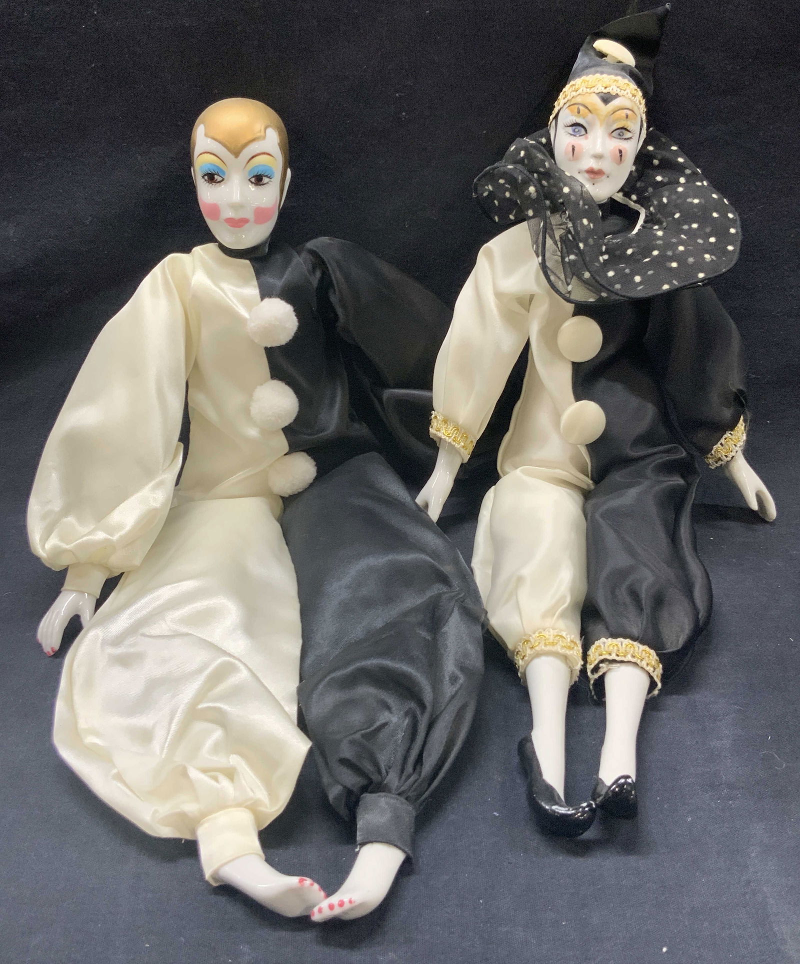 2 Vintage Hand Painted Porc Clown Dolls Silvestri+: Lot of 2 hand painted porcelain head, hands and feet clown dolls with fabric bodies. Both wearing half white and black outfits. 1 marked Russ Berrie &9 Co on tag, face of doll has gold hair and blue a
