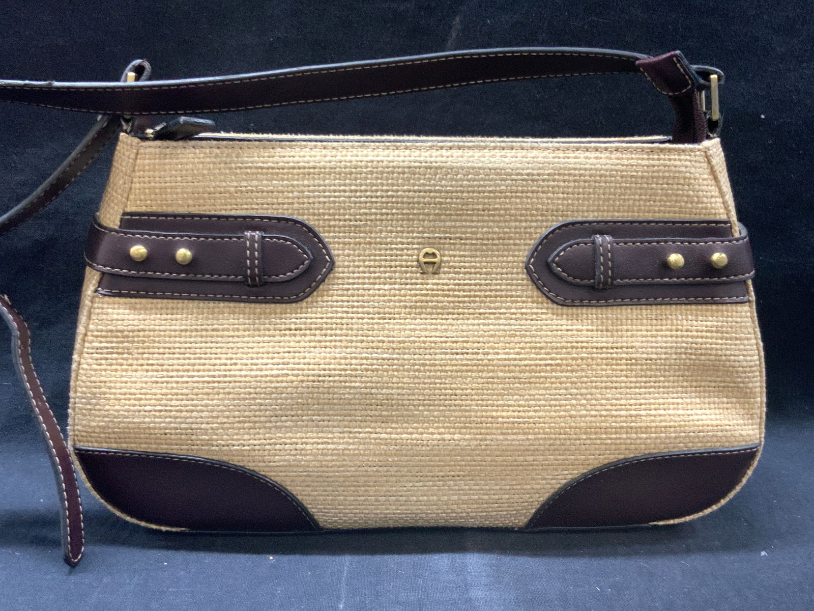 Etienne Afgner Woven Fiber & Leather Hand Bag: Marked on interior Etienne Afgner. Exterior has woven rattan style fibers with brown leather accents and top handle. Interior in lined with tan toned fabric and with 6 interior pockets. approx 7 inche