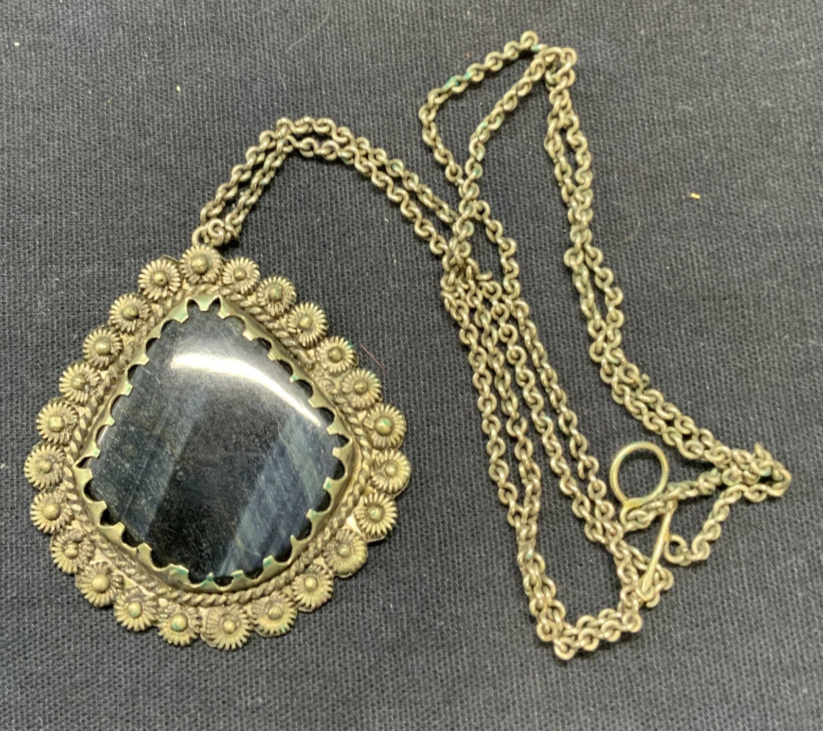 Vintage Silver Tn Black Gem Pendant Necklace: Vintage silver tone necklace with black gemstone pendant. Floral border detail on pendant. Drop length approx. 10.75 inches. Some surface wear including scratching observed. Estate jewelry, costume je