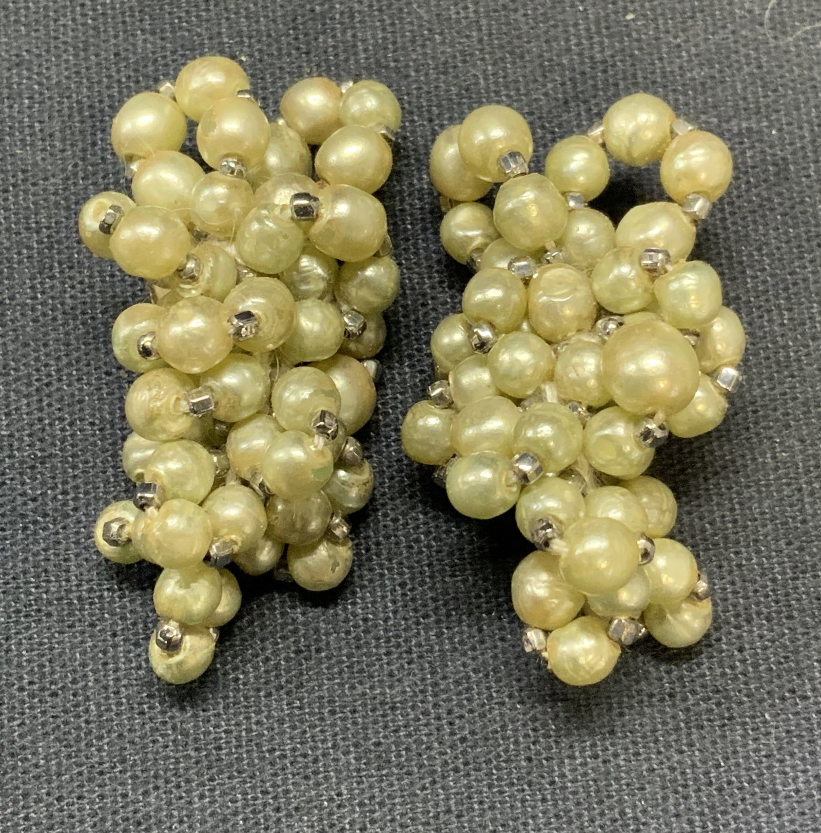 Vintage Pale Green Faux Pearl Earrings: Vintage pale green toned faux pearl beaded earrings. Clip on backing. Measure approx. 1.25 inches long. Some surface wear including scratching observed. Estate jewelry, costume jewelry, cocktail jewel