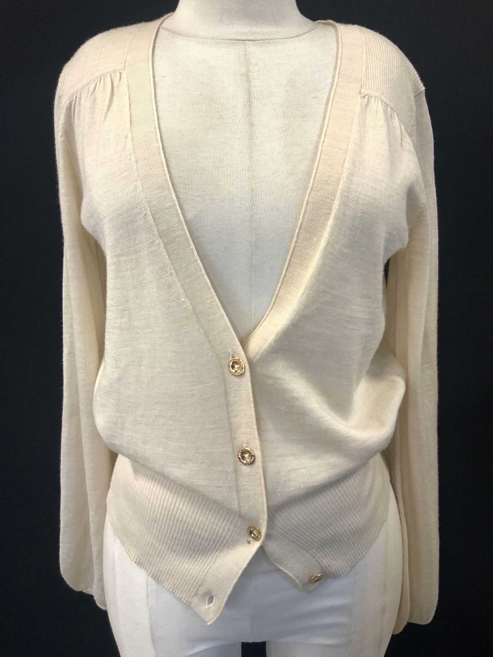 Juicy Couture Button Up Cardigan: Marked on tag Juicy Couture, tan toned with gold toned buttons and JC emblem on lower hemline of cardigan. Sleeve measures 20 inches from inseam, chest measures 19 inches across and torso measures 15
