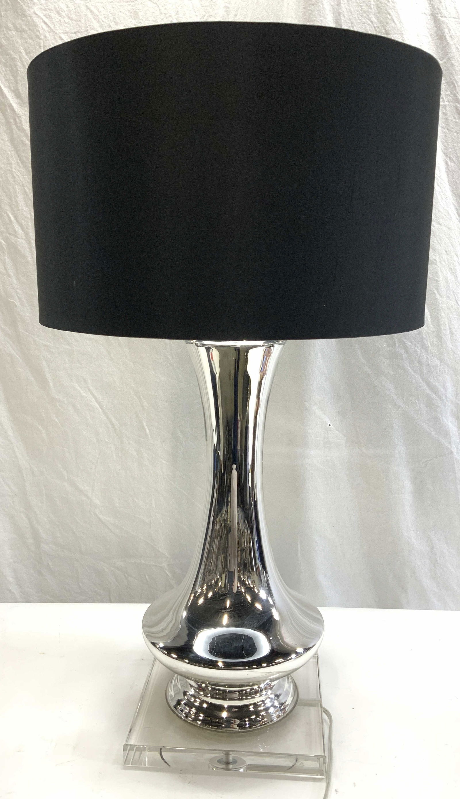 Modernist Silver Glass Lamp w Silk Drum Shade: 29.5 in. Tall modernist lamp with a clear lucite base, black silk drum shade with silver interior, and silver glass pedestal. Shade diameter is 17 in. Square lucite base has believed edges. Mild surfa