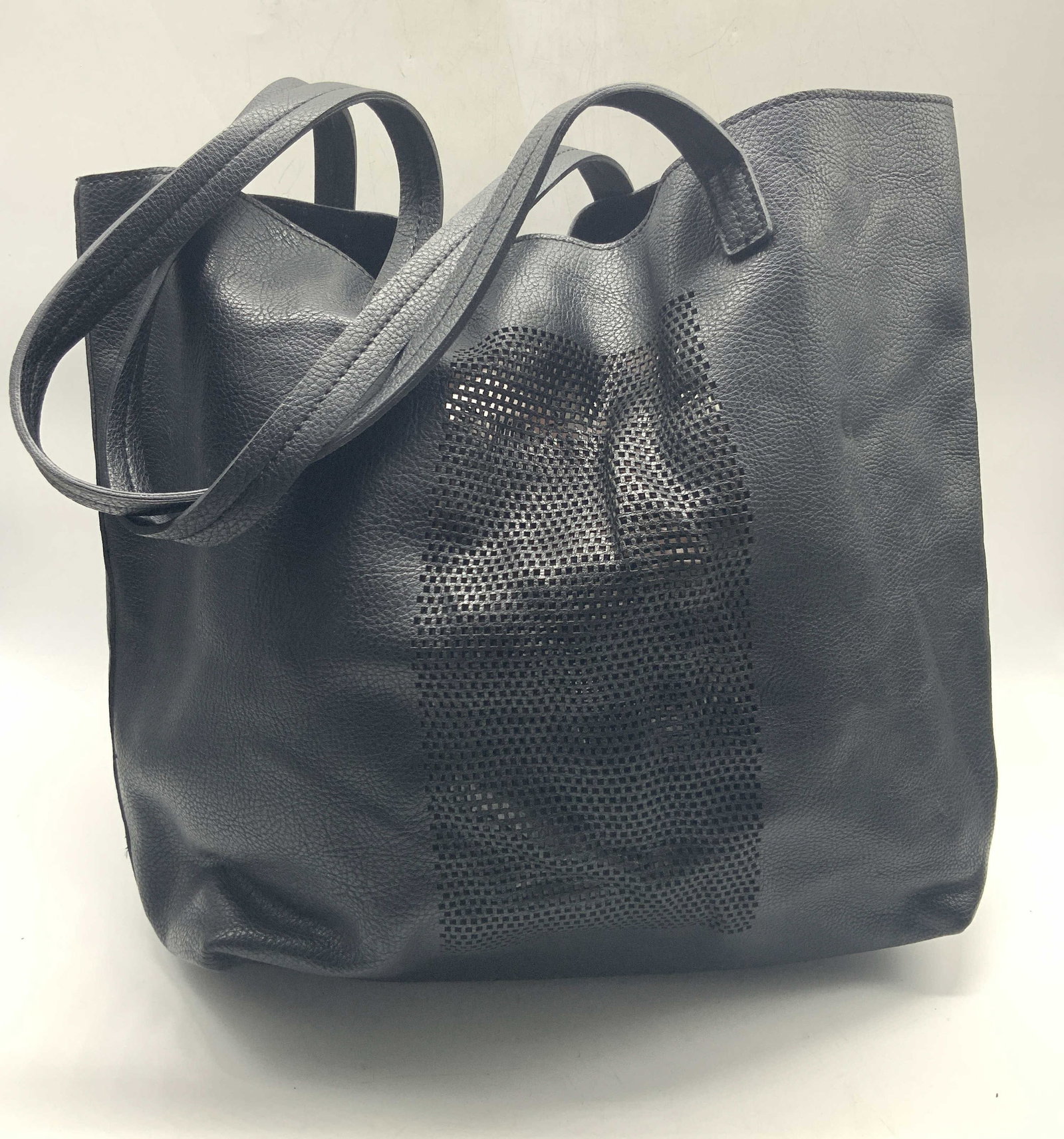 Black Leather & Suede Style Tote Bag: Black toned polyurethane tote bag with a suede style interior. Sides of the bag have square cut out patterns and top handles. Top handles drop length is 10.5 inches, approx 12 inches tall, 12 inches l