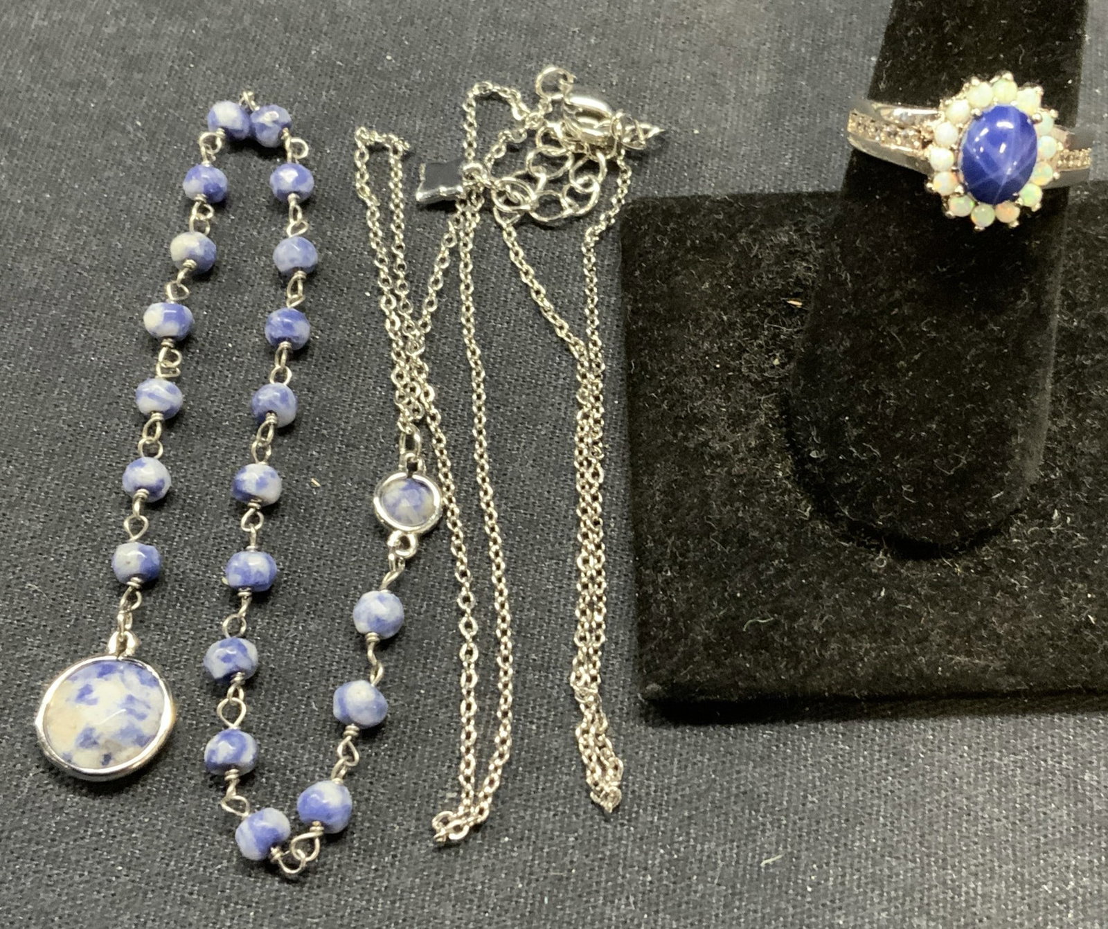 2 BCBGMAXAZRIA Necklace, Sterling Silver Ring: Lot of 2 jewelry pieces. BCBGMAXAZRIA silver tone pendant necklace with blue stone decoration. Designer hangtag on chain. Drop length approx. 9.5 inches. Pendant length approx. 7.5 inches. Sterling si