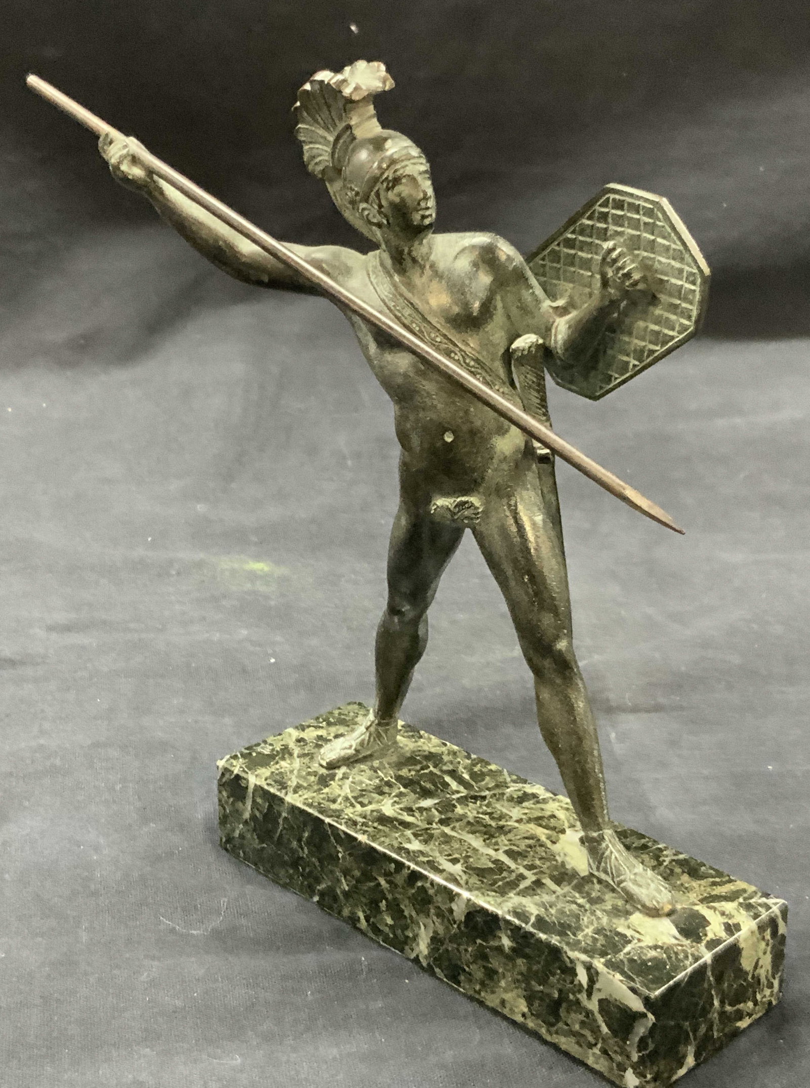 Bronze Roman Warrior Figural On Marble, France: A figure of a Roman warrior, nude with a sword, shield and helmet and a bronze spear in hand. Figure possibly made of patina bronze with a green coating over it. Affixed to marble base. Marked on unde
