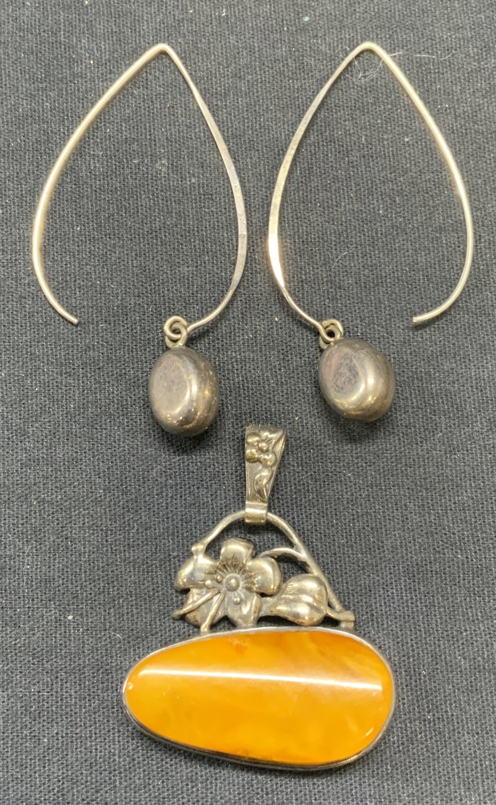 2 Sterling Silver Jewelry, Amber Pendant, Earrings: Lot of 2 jewelry pieces. Sterling silver and amber floral pendant. Marked 925. Measures approx, 1.25 x 1.5 inches. Total weight 9.6 grams. Sterling silver dangle earrings, hook backing. Marked India, 