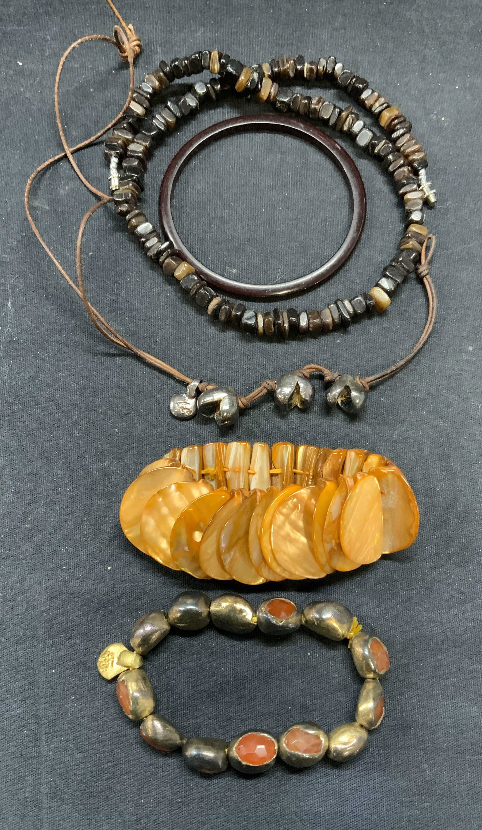 5 Jewelry Sterling Silver, Mother Of Pearl, More: Lot of 5 jewelry pieces. Signed sterling silver pendant necklace on brown cord. Signed illegibly. Drop length approx. 6.75 inches. Signed gilt sterling silver and orange gemstone beaded stretch bracel