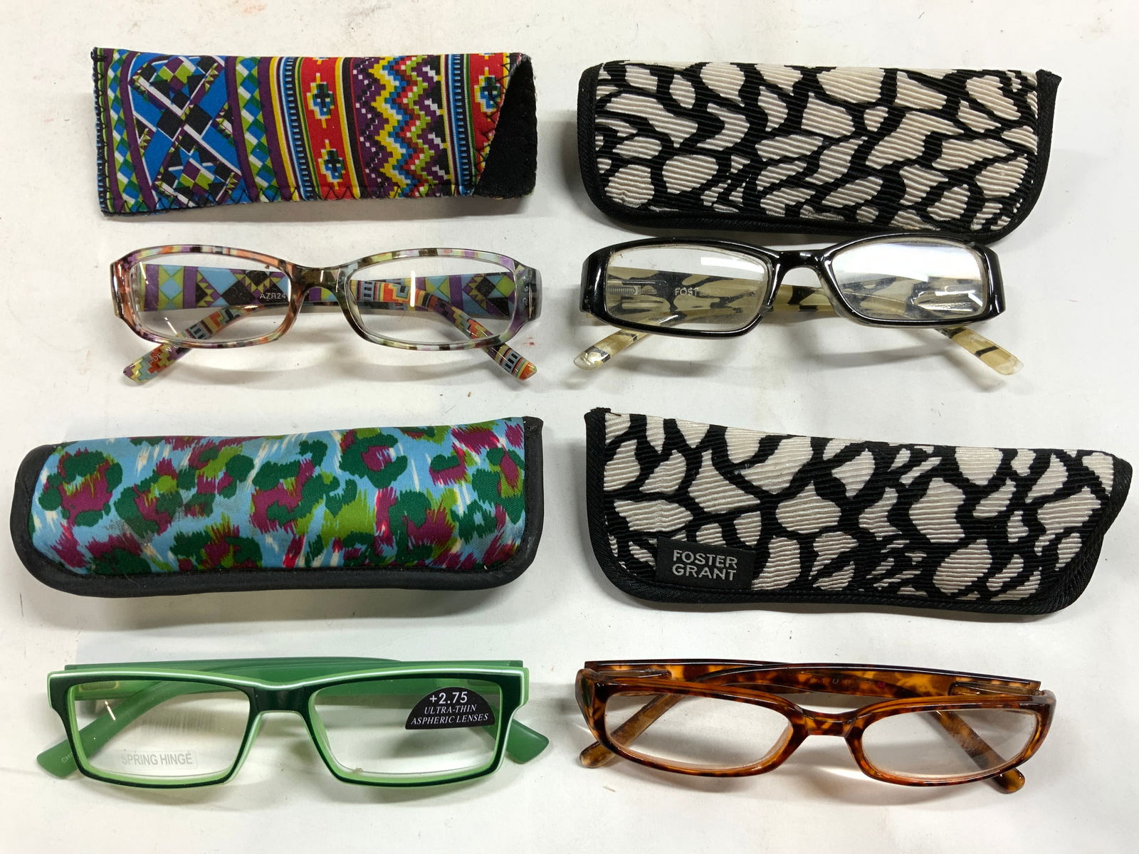 Lot 8 Glasses & Cases, FOSTER GRANT More: Lot includes 4 pairs of glasses, (1 marked FOSTER GRANT) & 4 eyeglass cases (2 of which have FOSTER GRANT tags). Each piece in lot have unique multi toned prints. Largest pair of glasses measure appro