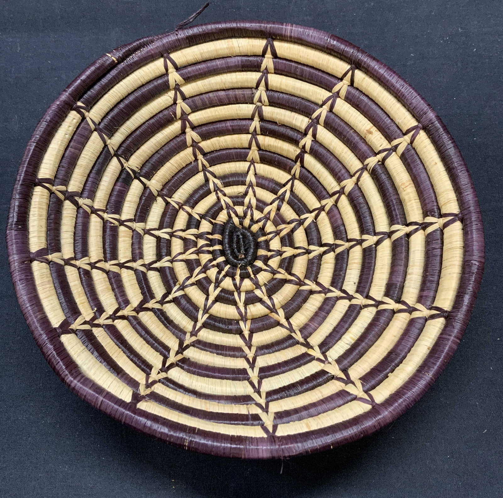 Handmade Tan & Brown Woven Straw Bowl: Handmade Tan and brown toned woven straw bowl with geometric pattern. Measures approx. 10.25 x 3 inches. Some surface wear including pulling observed. Bowl, straw bowl, woven bowl, geometric bowl, tan