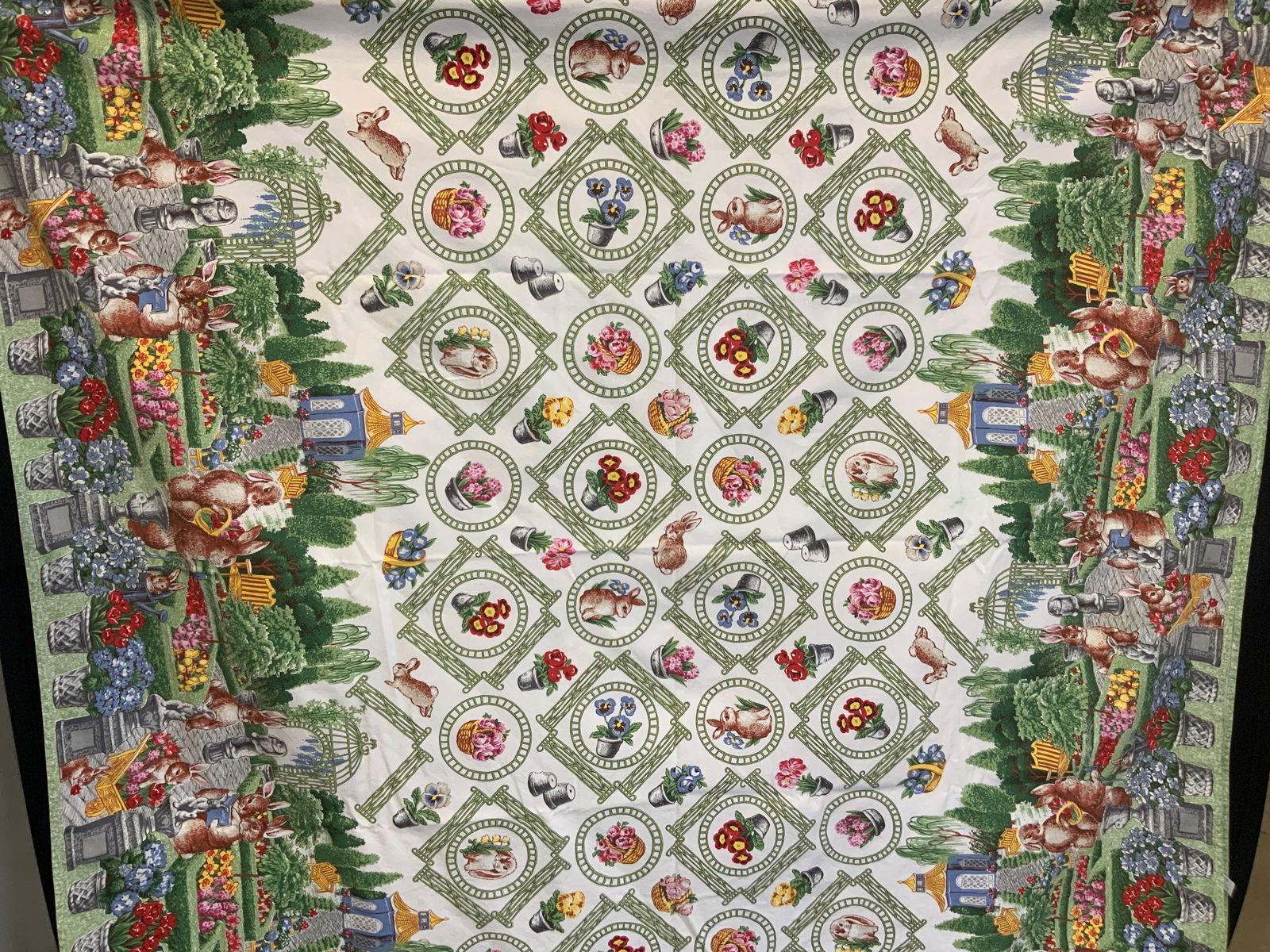 Wilton Court Cotton Easter Tablecloth, Turkey: Marked on tag Wilton Court, 100% cotton, made in Turkey. Adorn with motifs of rabbits on outer edges in gardens with green designs with flowers and rabbits within the centers. Approx 96 x 58 inches. M