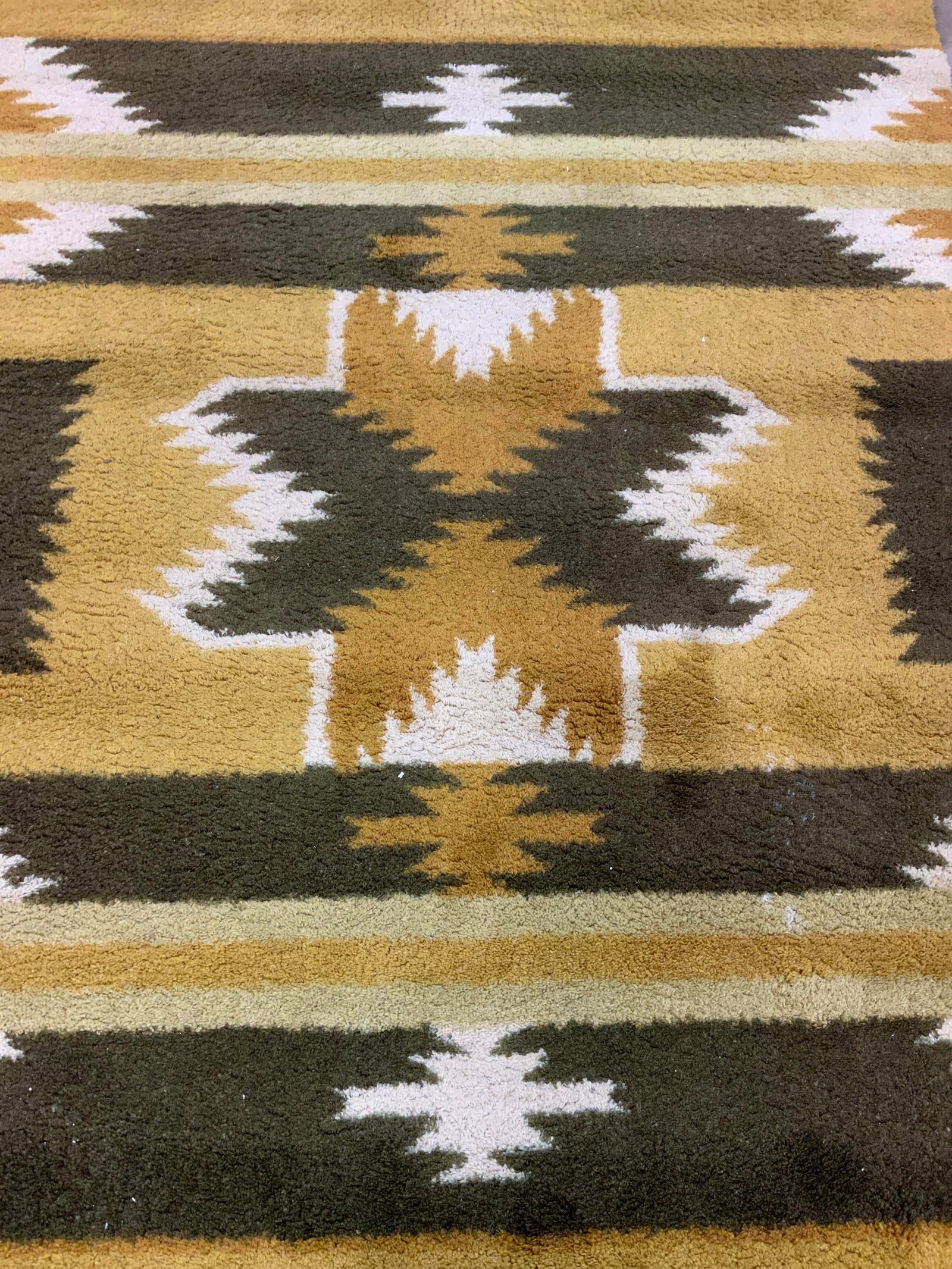 MILLIKEN ALTA MESA MOJAVE Area Rug 8ft4in: Tag on underside reads MILLIKEN ALTA MESA MOJAVE YUMA BROWN. Rug has tribal style geometric detail with tones of olive, cream & mustard. Rug measures approximately 100 inches long 68 inches wide. Rug,