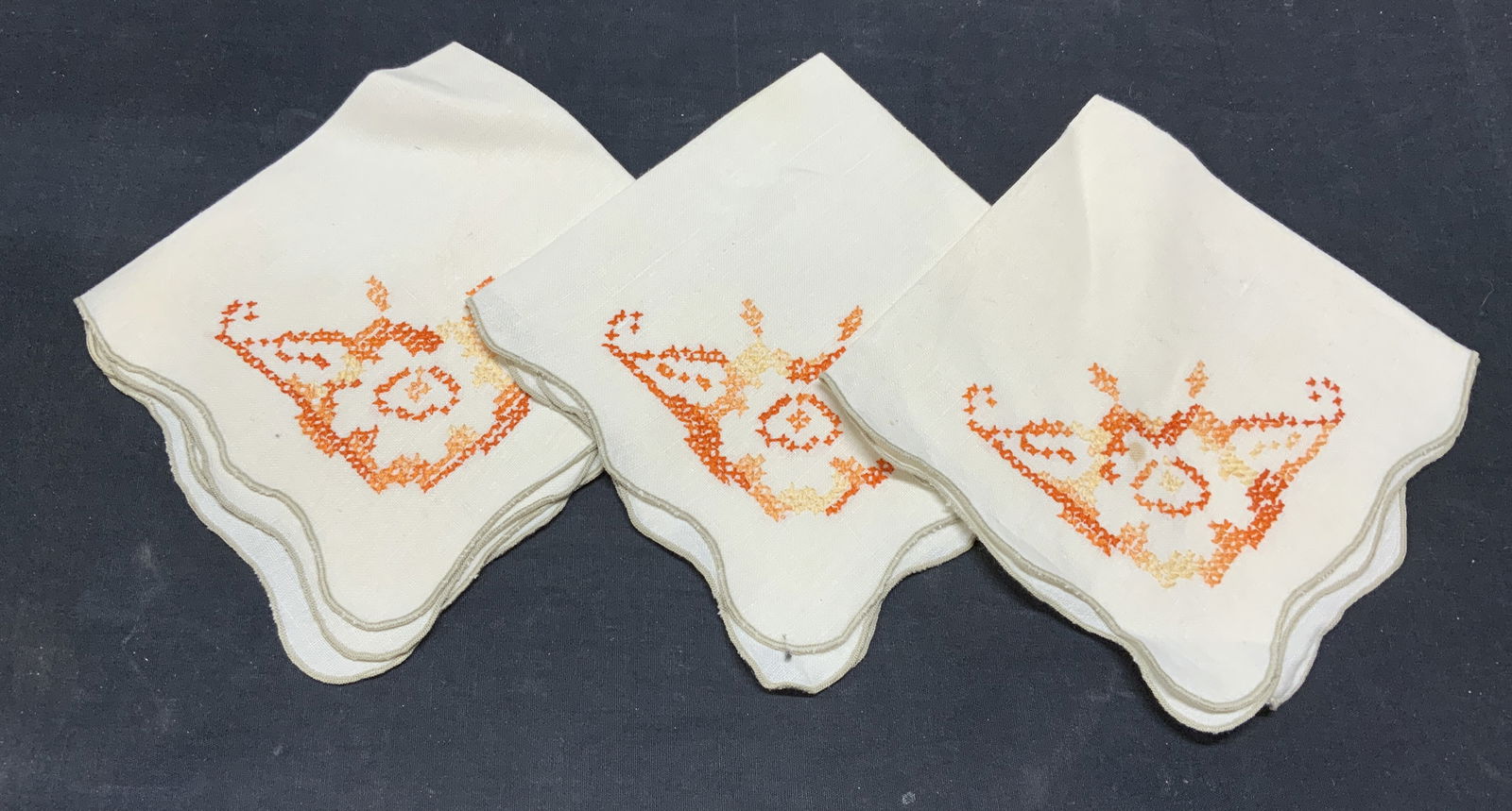 Set 11 Beige Linen Embroidered Napkins: Set of 11 beige toned linen napkins with orange embroidered geometric pattern. Measure approx. 14.5 x 14 inches. All pieces have some wear too material including blemishes observed. Napkins, beige nap
