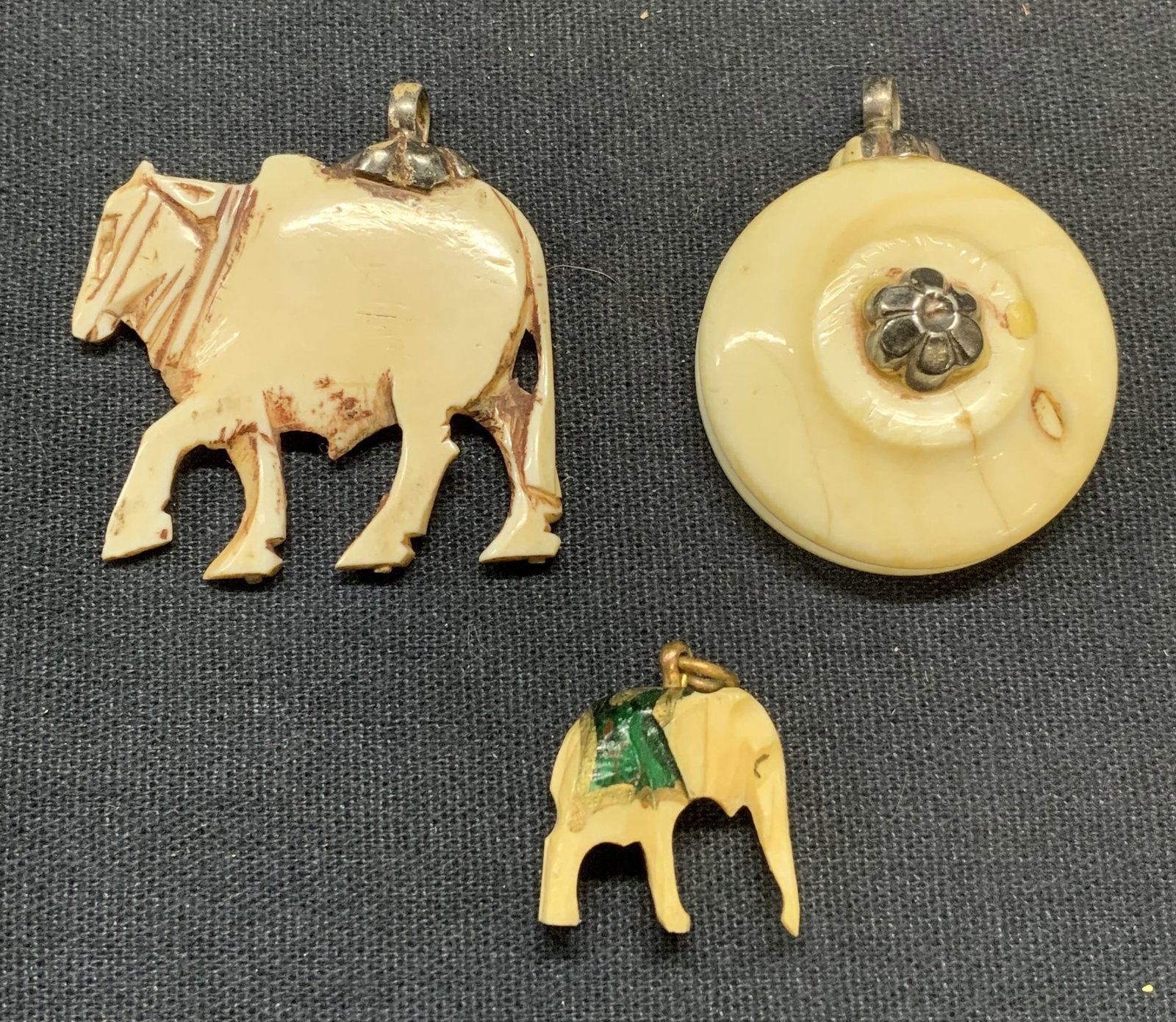 Lot 3 Carved Bone & Sterling Silver Pendants: Lot of 3 jewelry pieces. Vintage carved bone pendants. Round pendant with flower, donkey pendant, and elephant pendant. 2 pieces with sterling silver accents. Test for sterling using PuriTEST kit. Lar
