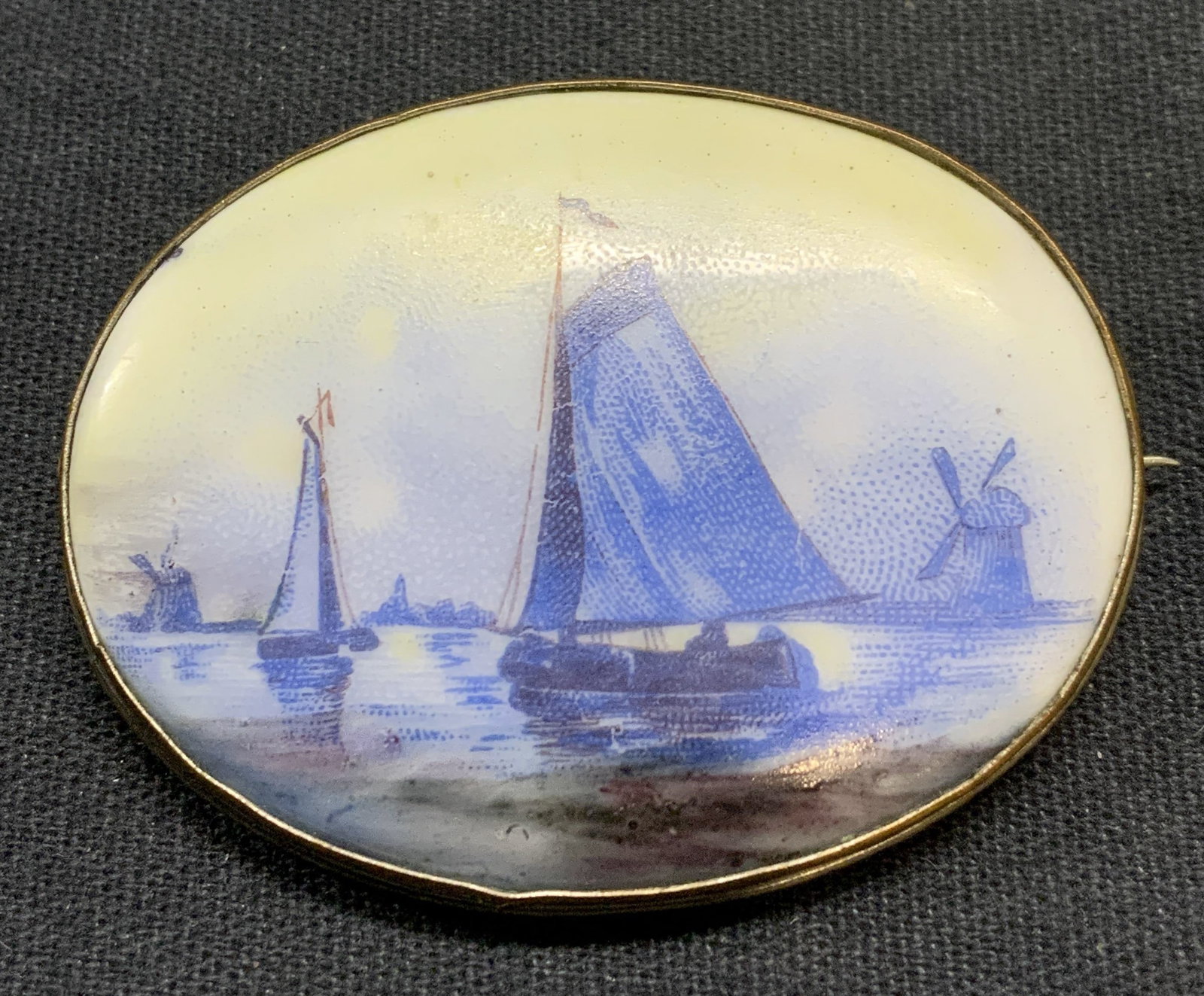 Vintage White & Blue Ceramic Boat Brooch: Vintage silver tone brooch with white and blue boat motif. Possibly ceramic or resin. Hinge pin to underside. Measures approx. 1.5 x 1.75 inches. Some surface wear including scratching observed. Estat