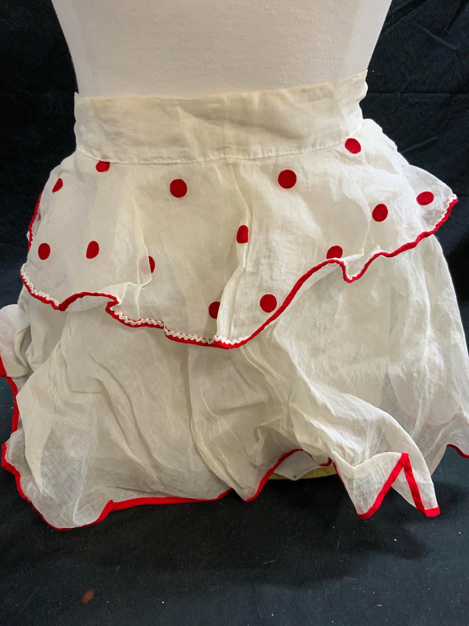 Vintage sheer White & Red Dot Apron: Vintage sheer white apron with red dot and trim. Material feels synthetic. Measures approx. 23 inches across waist. Wear to material including blemishes observed. Apron, sheer apron, white apron, dot 