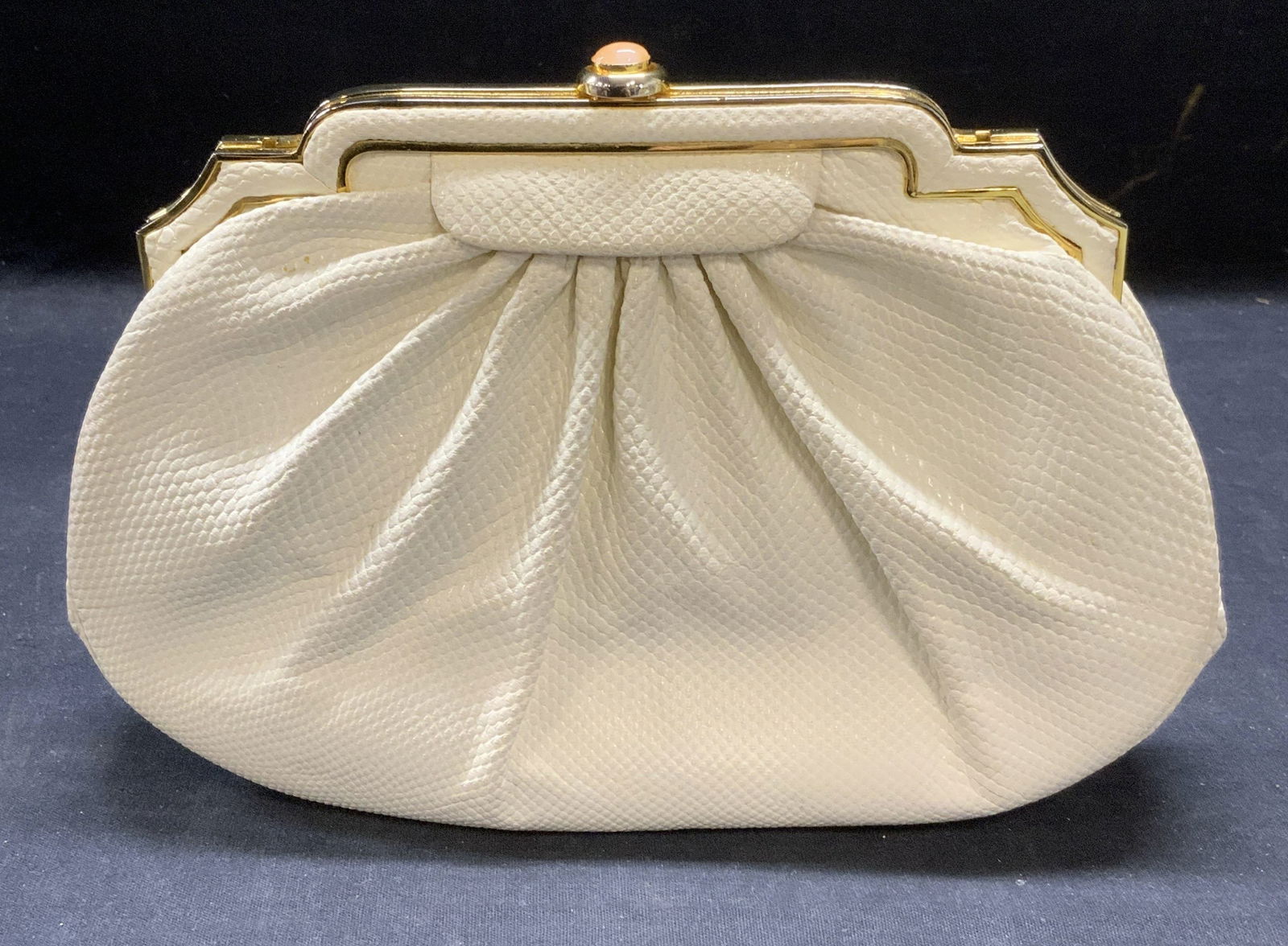 Vintage Judith Leiber White Reptile Leather Handbag: Vintage Judith Leiber for Bonwit Teller white reptile leather handbag, gold tone hardware with pink Cabochon. Push clasp. 1 zipper pocket and 1 slip pocket to interior. Measures approx. 8.75 x 2 x 6 i