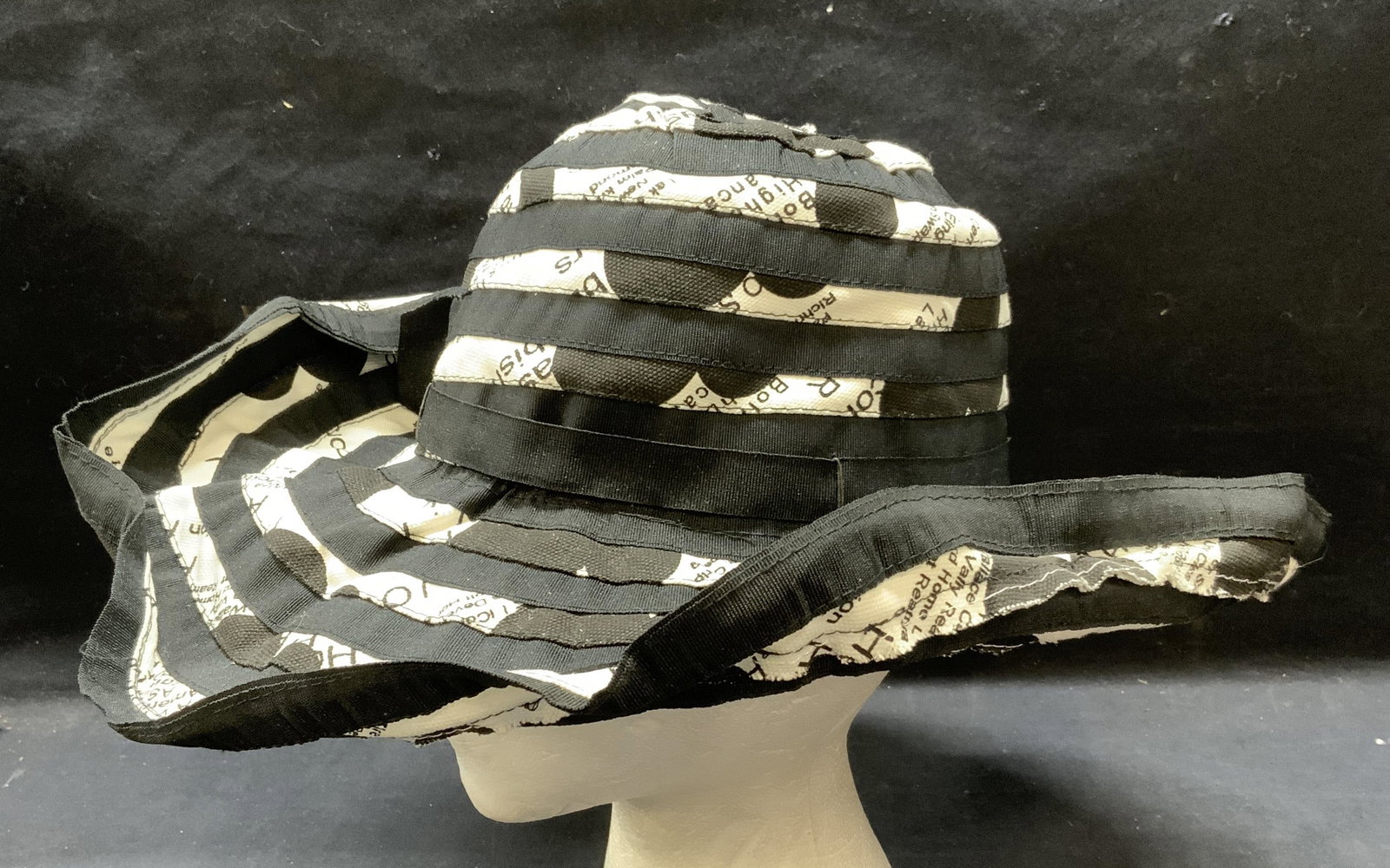 Black & White Striped Graphic Print Hat: Black and white striped hat with graphic print. Material feels like cotton. Measures approx. 7 inches wide. Some wear to material including minor blemishes observed. Ladies hat, ladies black hat, ladi
