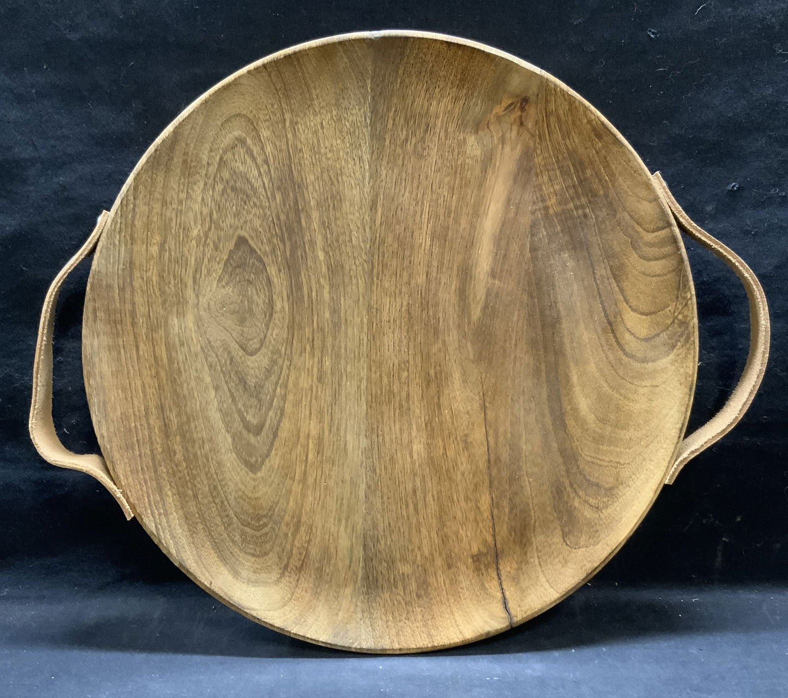Round Wood Tray with Leather Handles: Round wooden tray with leather handles. Measures approx. 15.5 inches diameter. Some surface wear including scratching observed. Tray, wood tray, round tray, tray with handles, tableware, table decor a