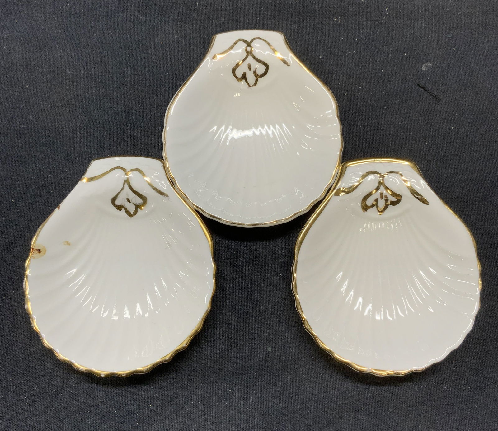 3 Foley China Cunard Steamship Shell Dishes England: Set of 3 vintage Foley bone china shell dishes with gilt decoration. Embossed surface. Measure approx. 3.5 x 3 inches each. Trademarked to undersides. Marked The Cunard Steamship Company to undersides