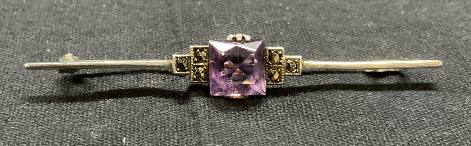Vintage Sterling Silver Amethyst Marcasite Brooch: Vintage sterling silver brooch with amethyst and marcasite decoration. Hinge pin to underside. Measures approx. 2.5 inches long. Total weight 3.5 grams. Tests for sterling suing PuriTEST kit. Estate j