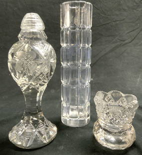 Lot 3 Crystal & Glass Vessels, Shaker and Vases: Lot included 1 crystal vase, 1 crystal salt shake & 1 glass vessel. Each have geometric relief detail. Shaker has area with inward taper. Largest piece measures approximately 7 inches tall 2 inches wi