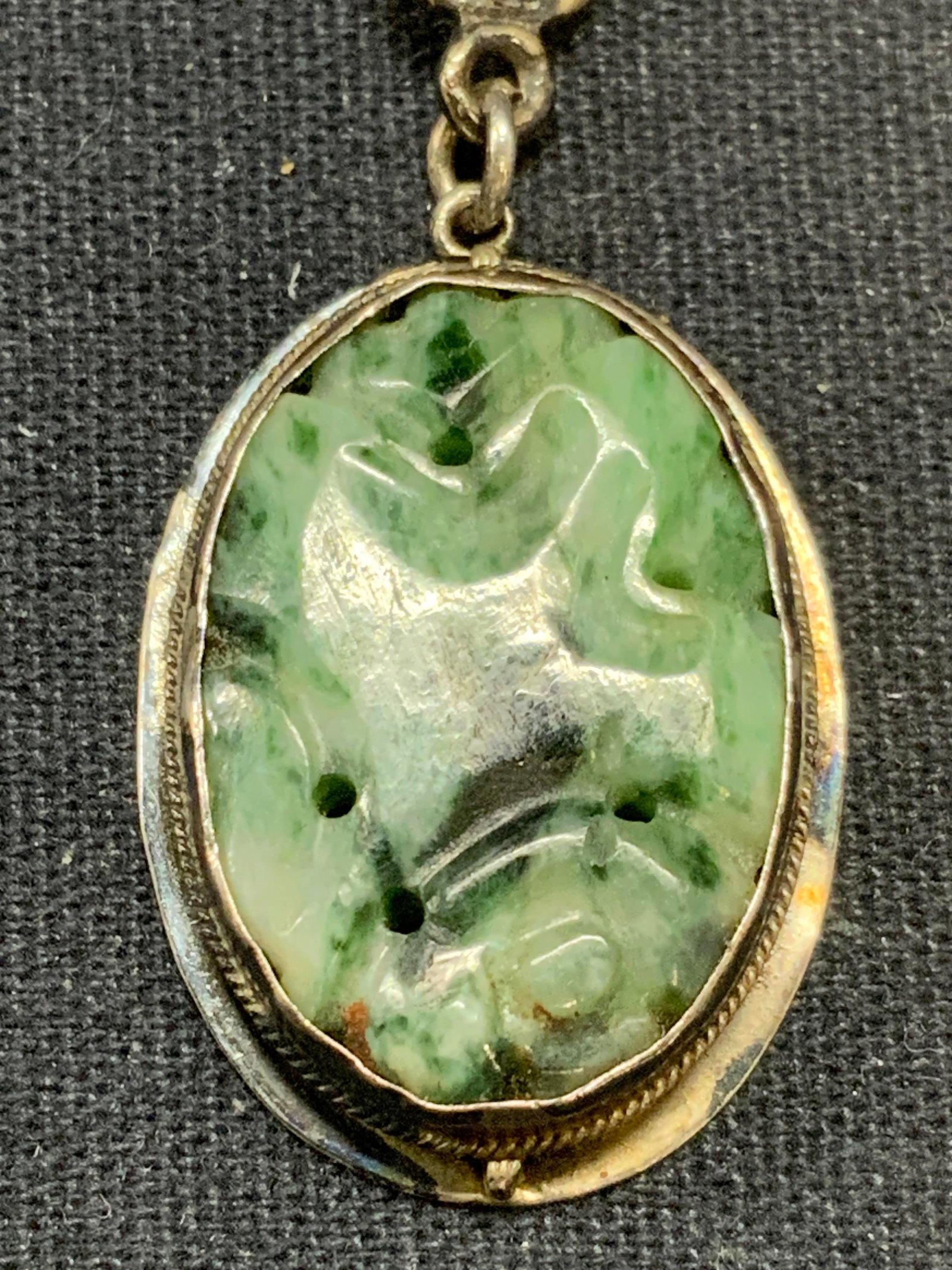 Sterling Silver Carved Stone Pendant Necklace: Vintage sterling silver pendant necklace with carved green stone. Marked sterling on pendant. Drop length approx. 8 inches. Pendant measures approx. 1 x .75 inches. Total weight 9.6 grams. Surface wea