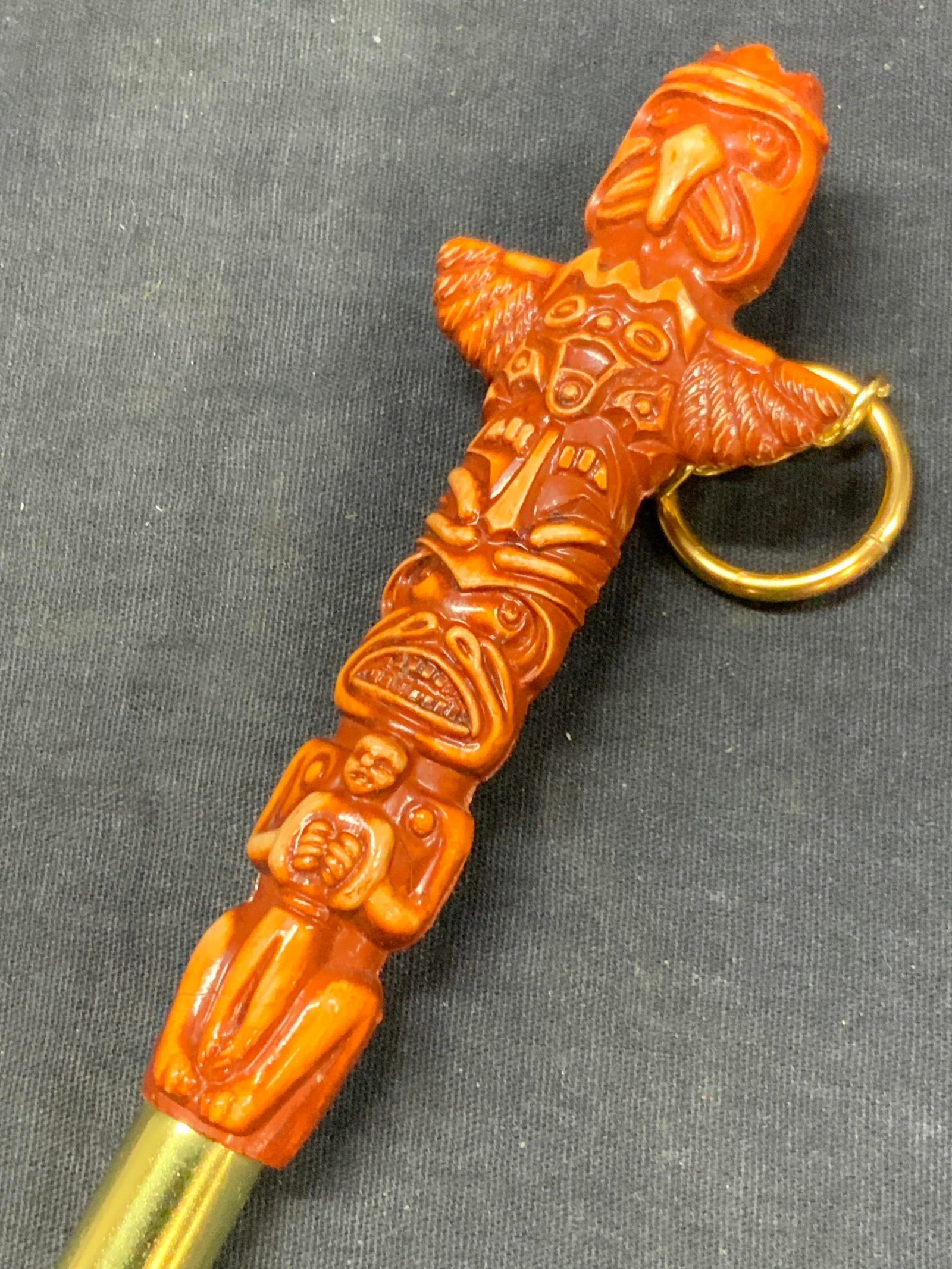 Guam Hilton Totem Table Brush. Japan: Marked in brush Guam Hilton, Japan. Handle resembles a totem with various animal depictions in a hard composite with a black brush and red bristles. Approx 10.5 inches long. Minor wearing to brush and